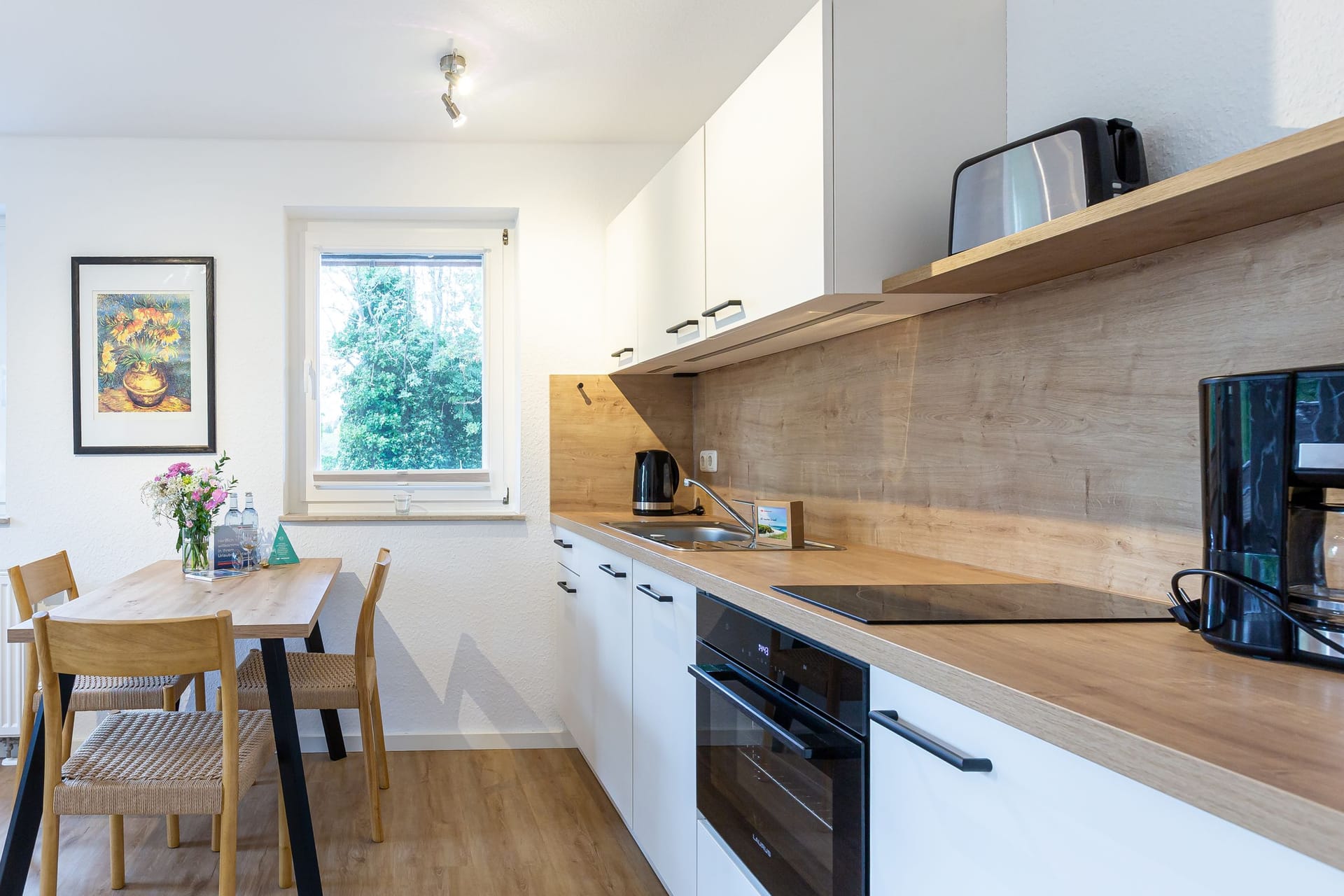 Moderne Küche mit Esstisch und Kochstelle