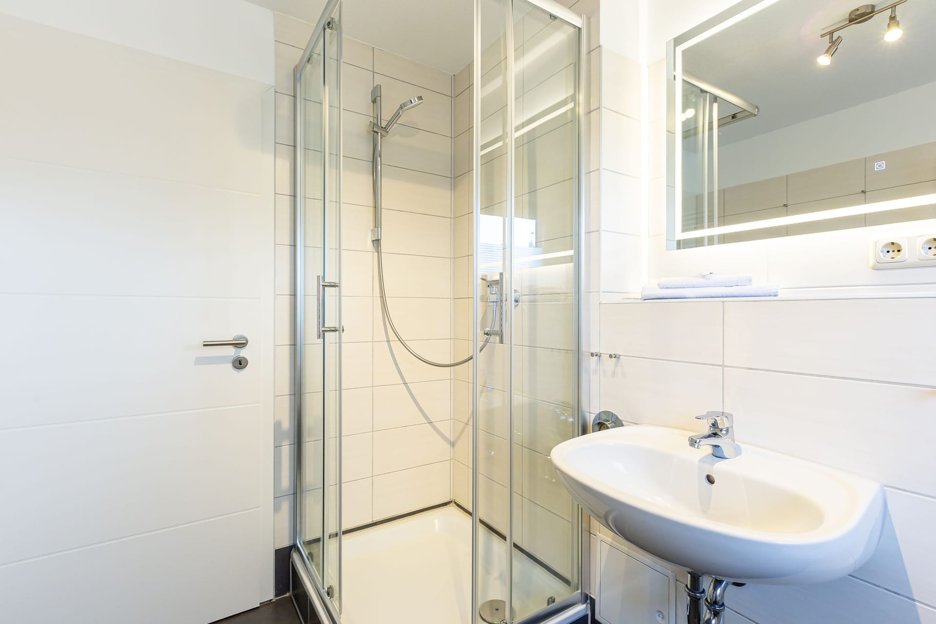 Helles Badezimmer mit Duschkabine und Waschbecken