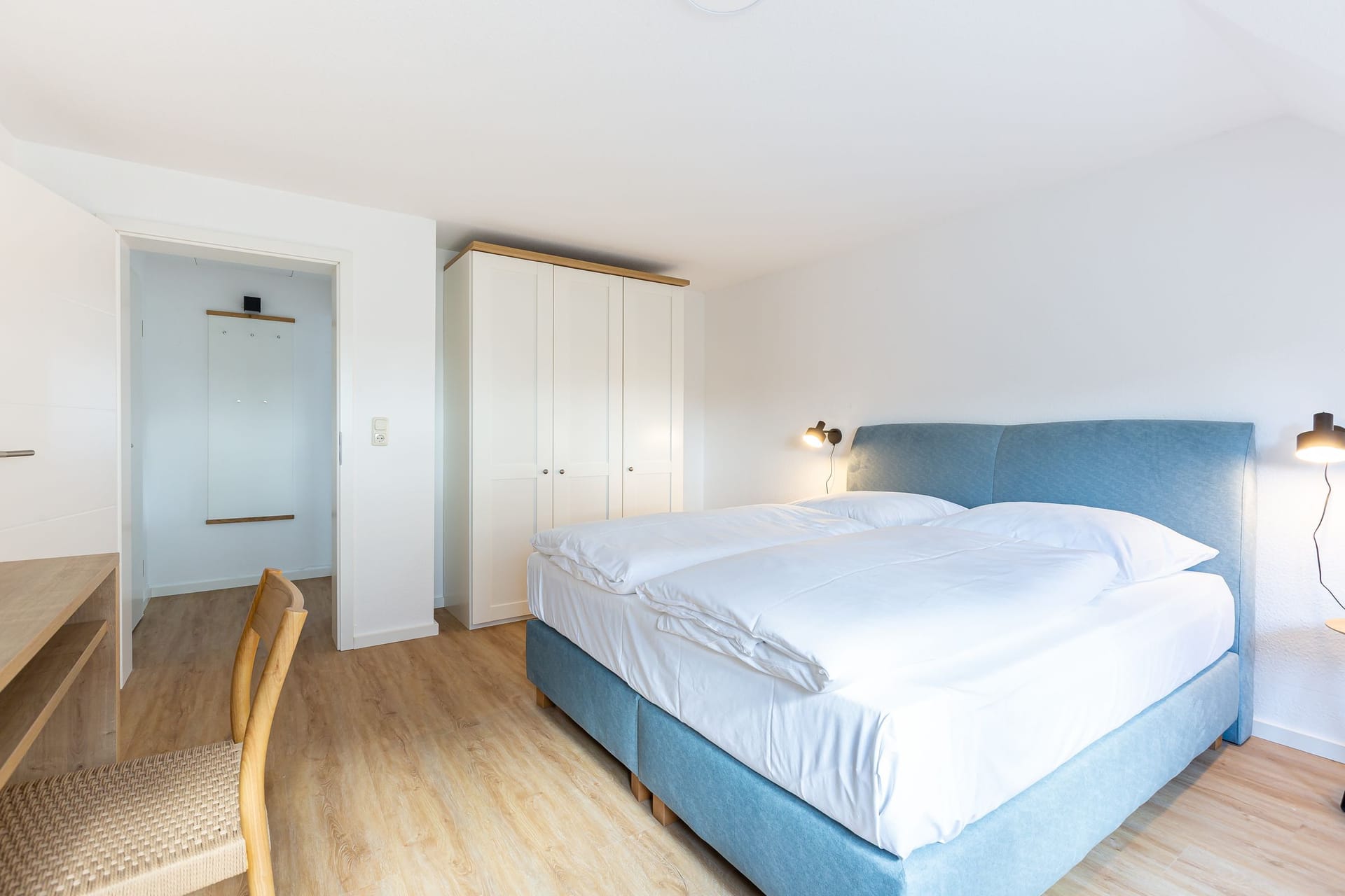 Helles Schlafzimmer mit Doppelbett und Schreibtisch