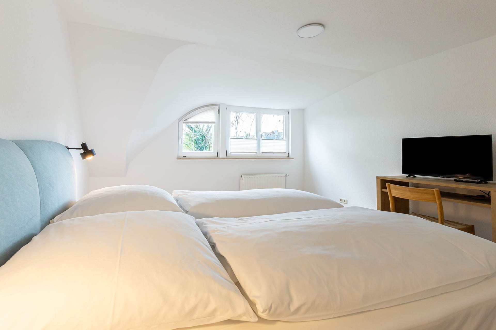 Schlafzimmer mit Doppelbett und Schreibtisch