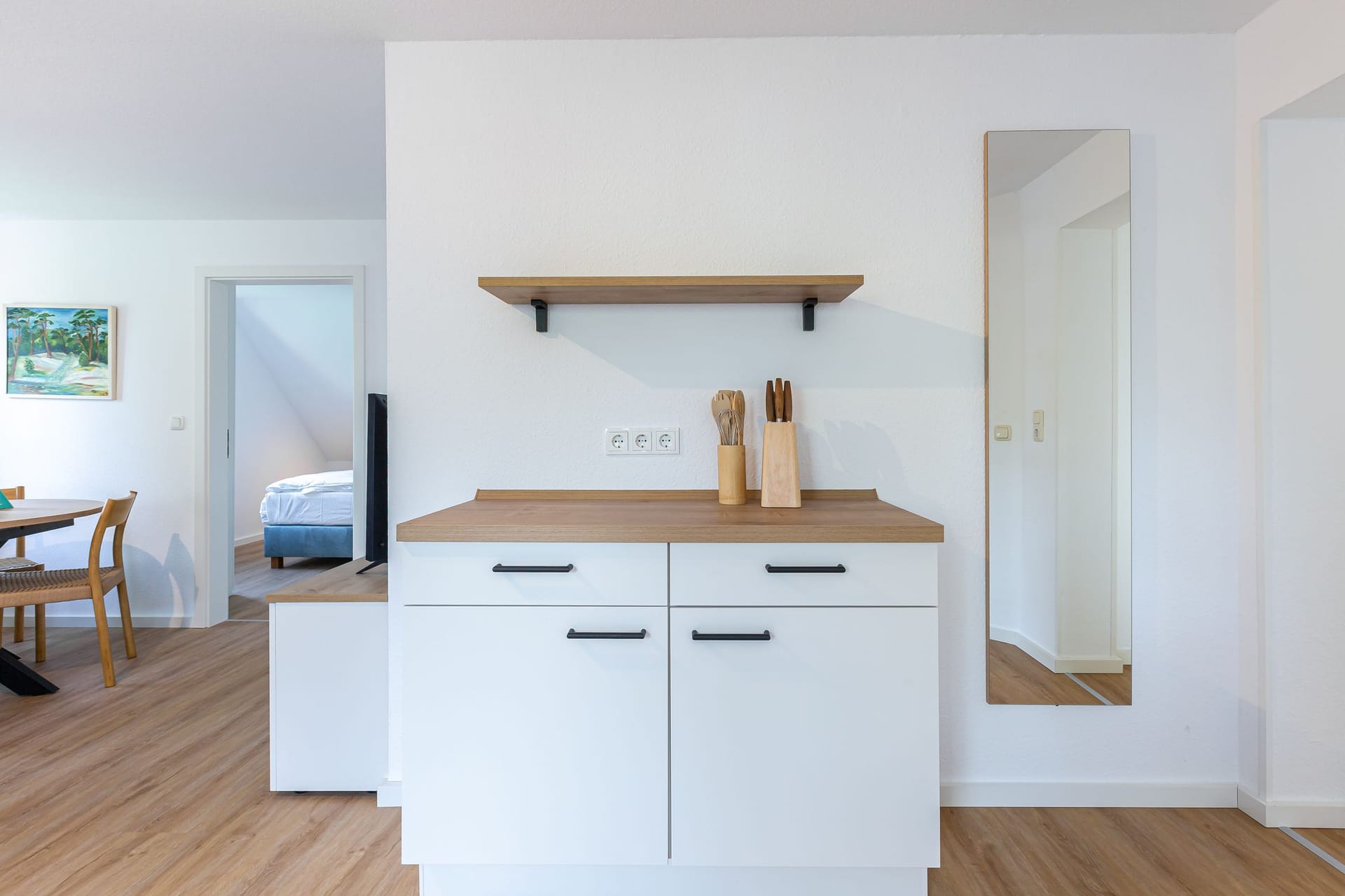 Moderne Küche mit Holzregal und Kochutensilien