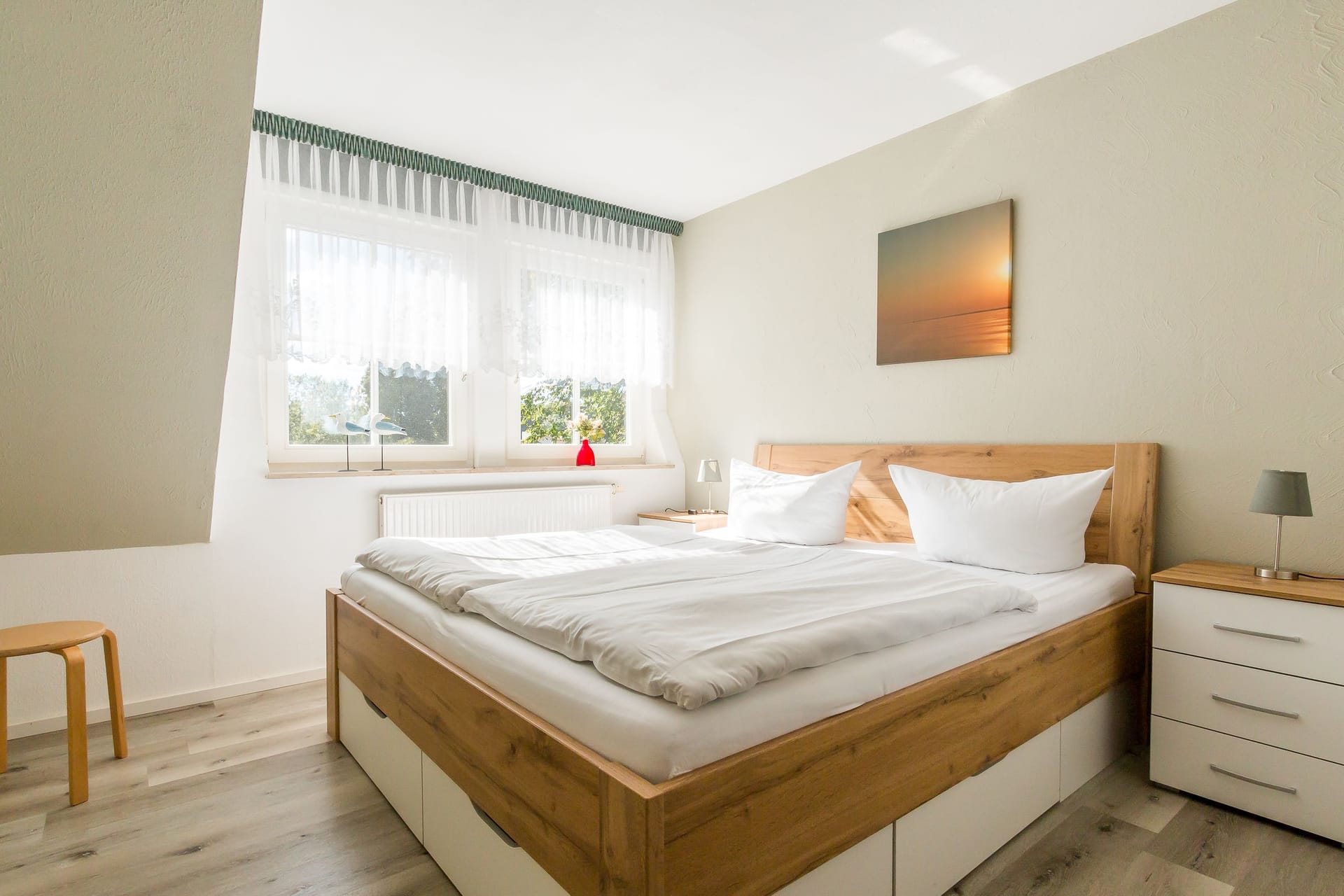 Helles Schlafzimmer mit Doppelbett und Fenster