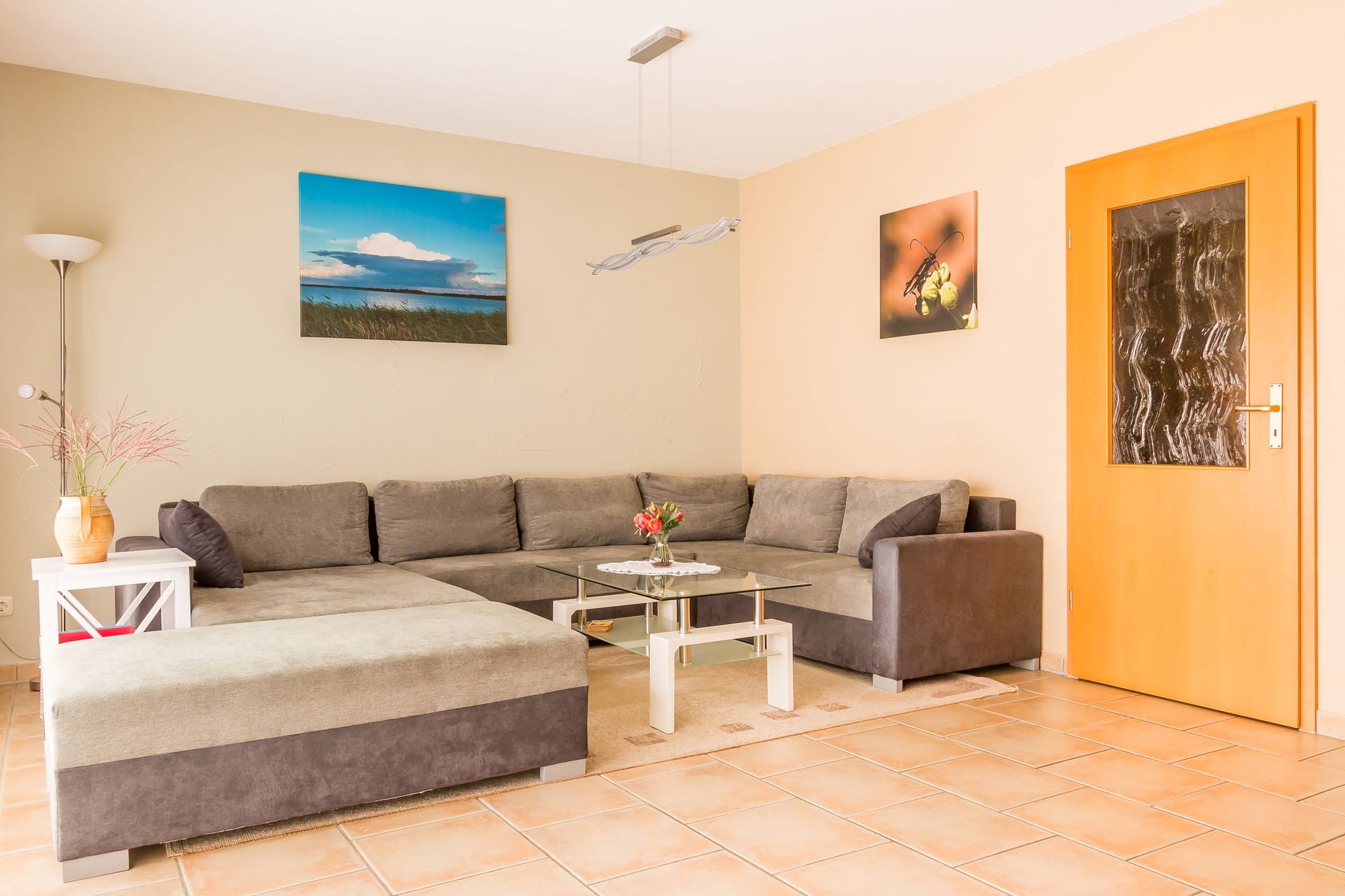 Geräumiges Wohnzimmer mit Sofa und Glas-Tisch