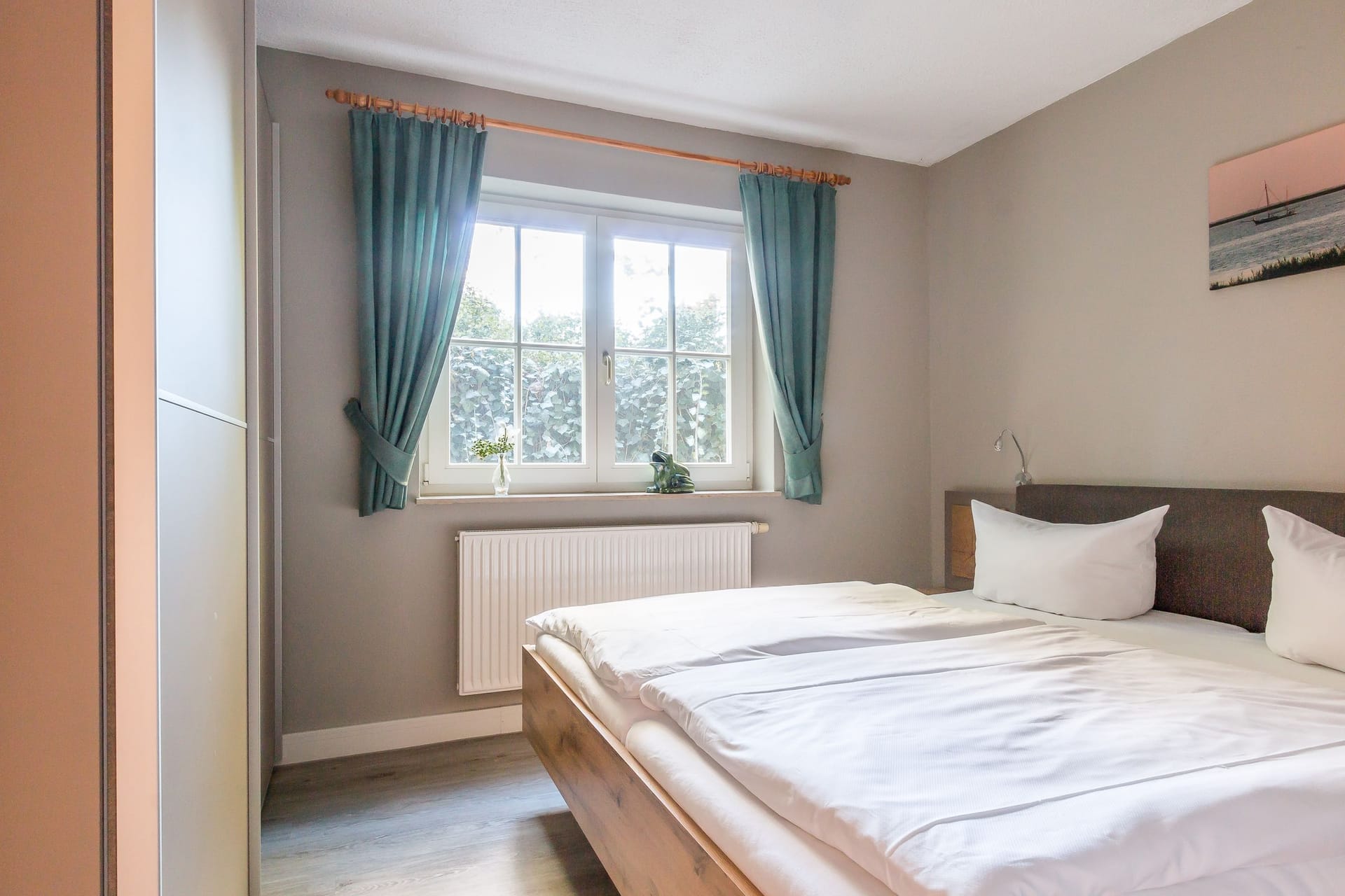 Helles Schlafzimmer mit Doppelbett und Fenster