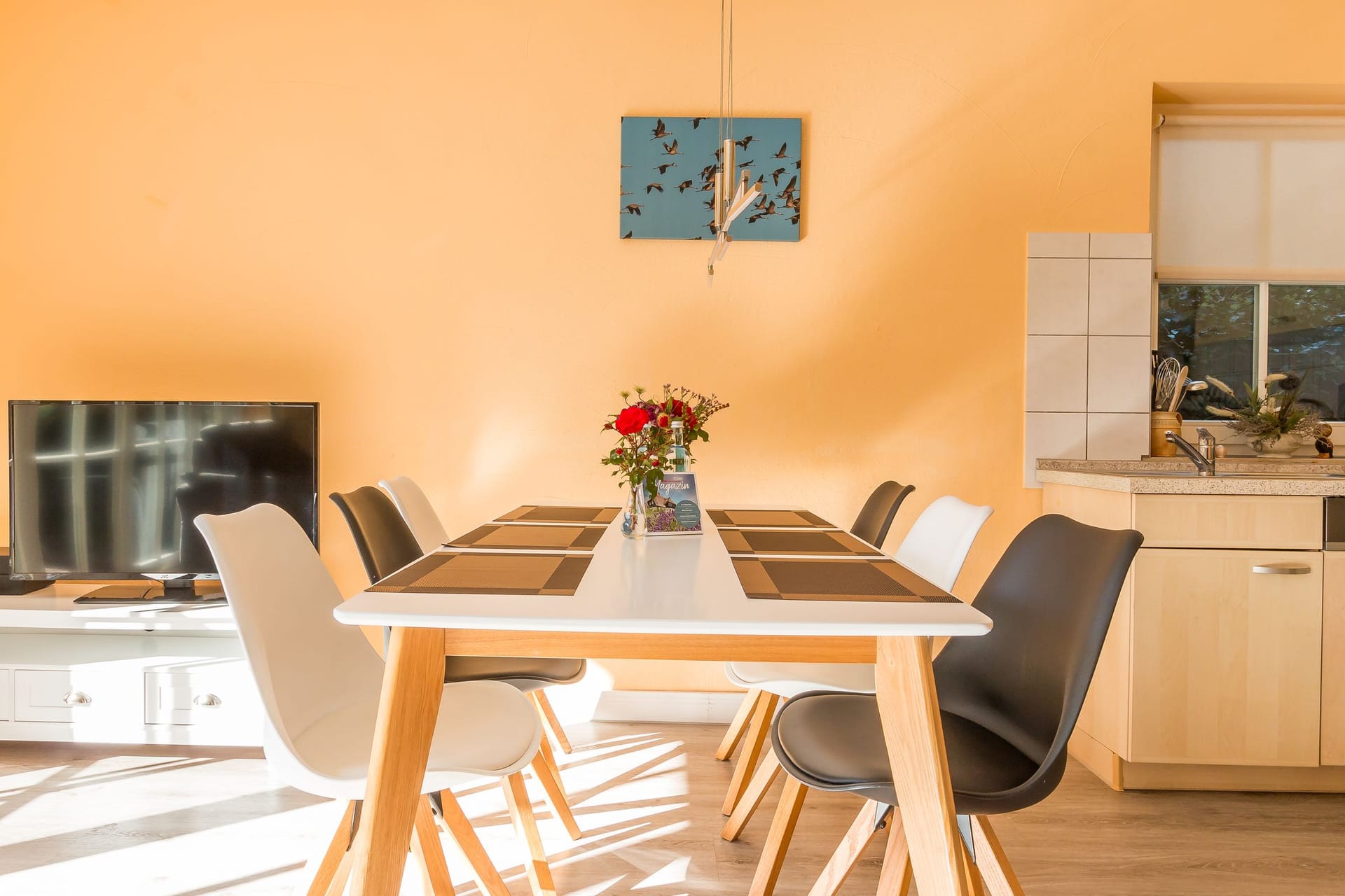 Helle Küche mit Esstisch und Fernseher
