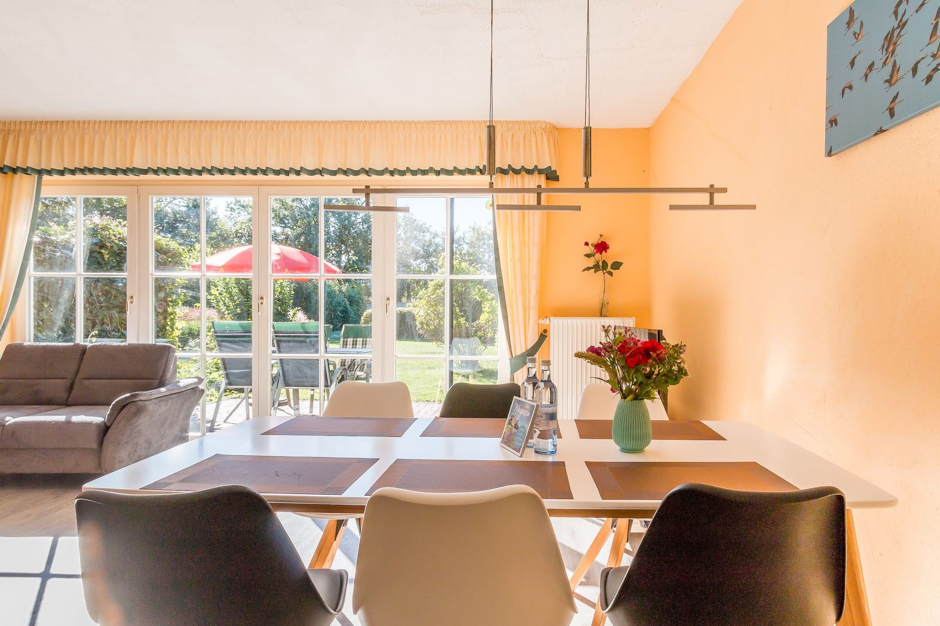 Helles Wohnzimmer mit Esstisch und Sofa