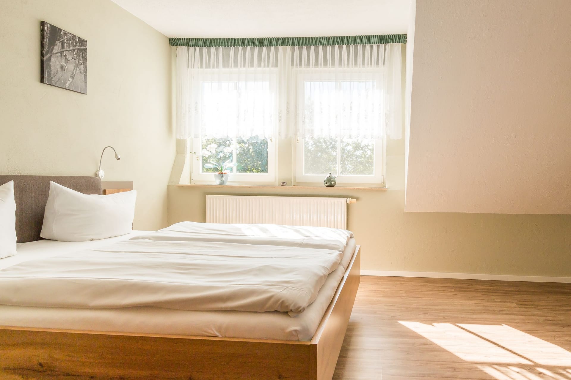 Helles Schlafzimmer mit Doppelbett und Fenstern