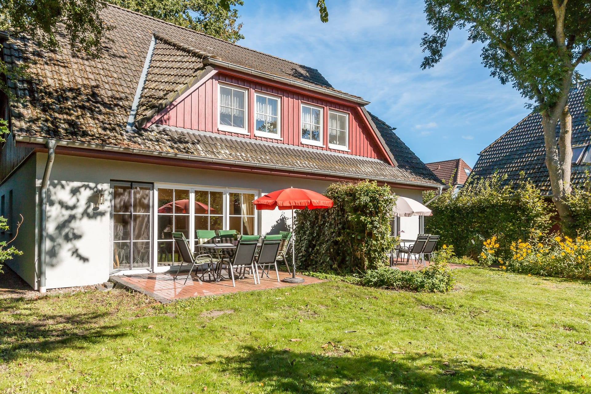 Terrasse mit Gartenmöbeln und Sonnenschirmen