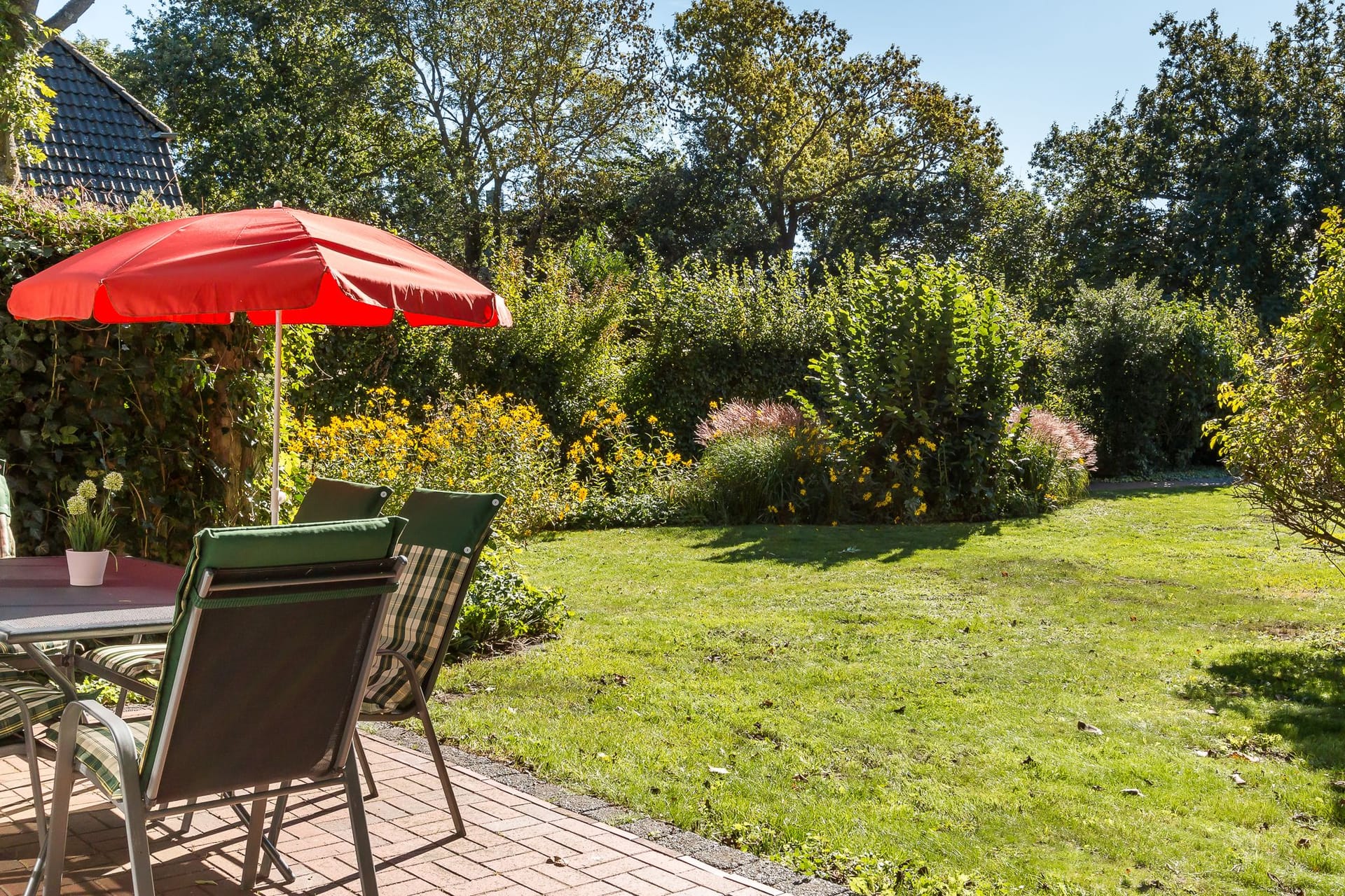 Terrasse mit Tisch, Stühlen und Gartenblick