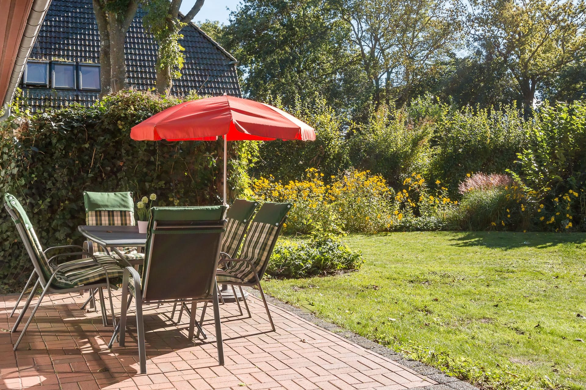 Terrasse mit Tisch und Sonnenschirm