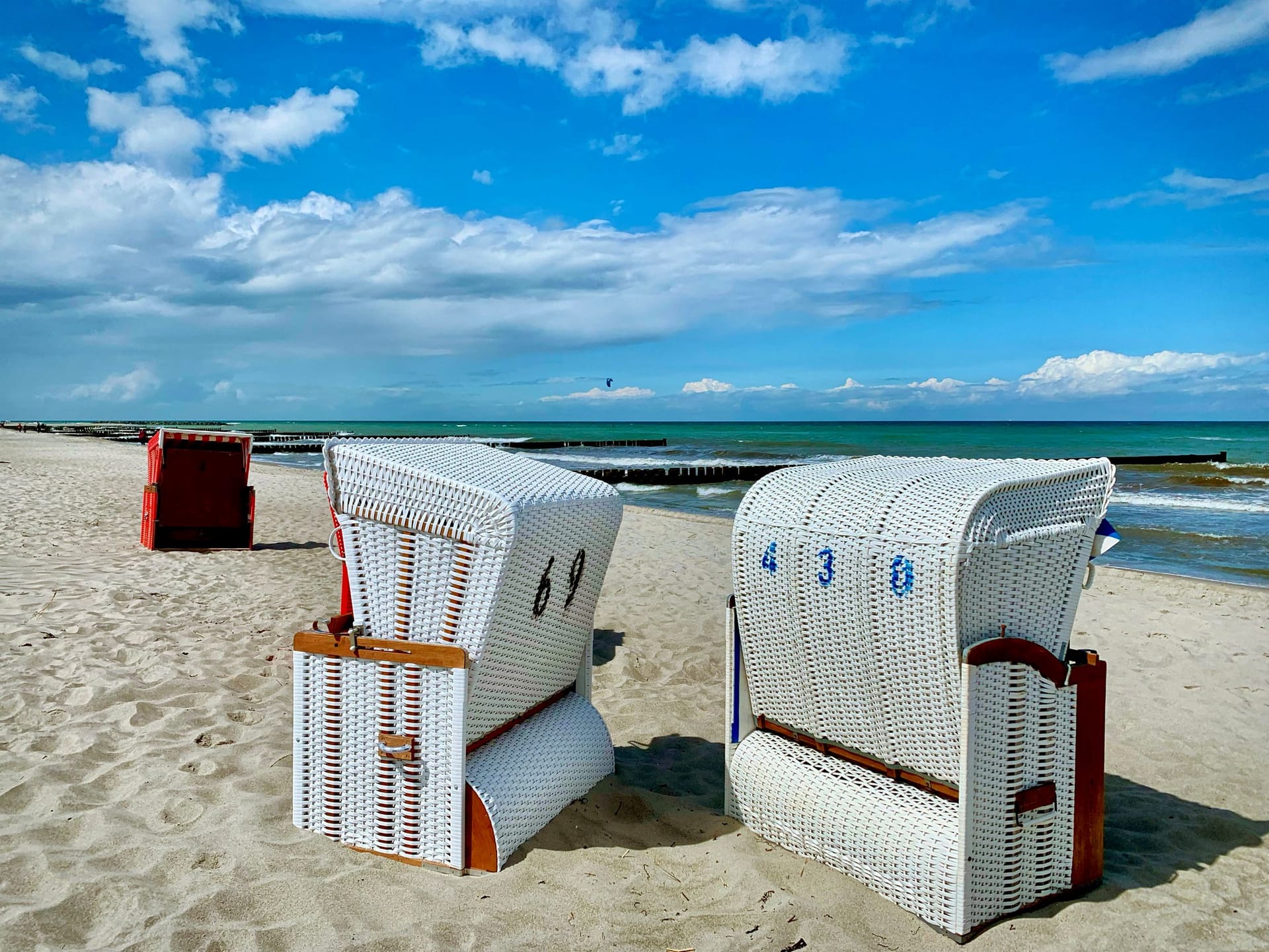 Strand mit weißen Strandkörben und blauem Himmel
