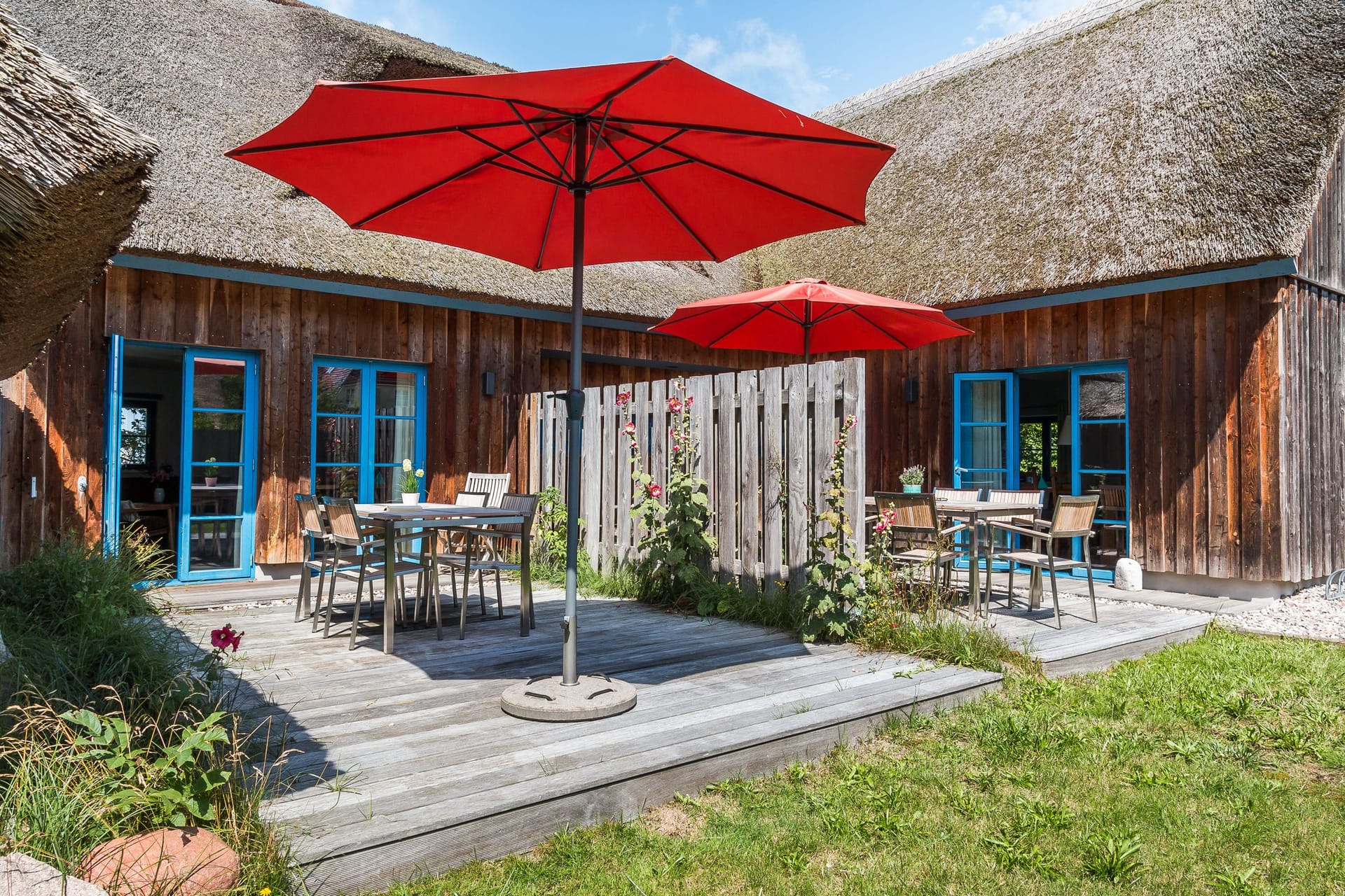 Terrasse mit roten Sonnenschirmen und Sitzmöglichkeiten