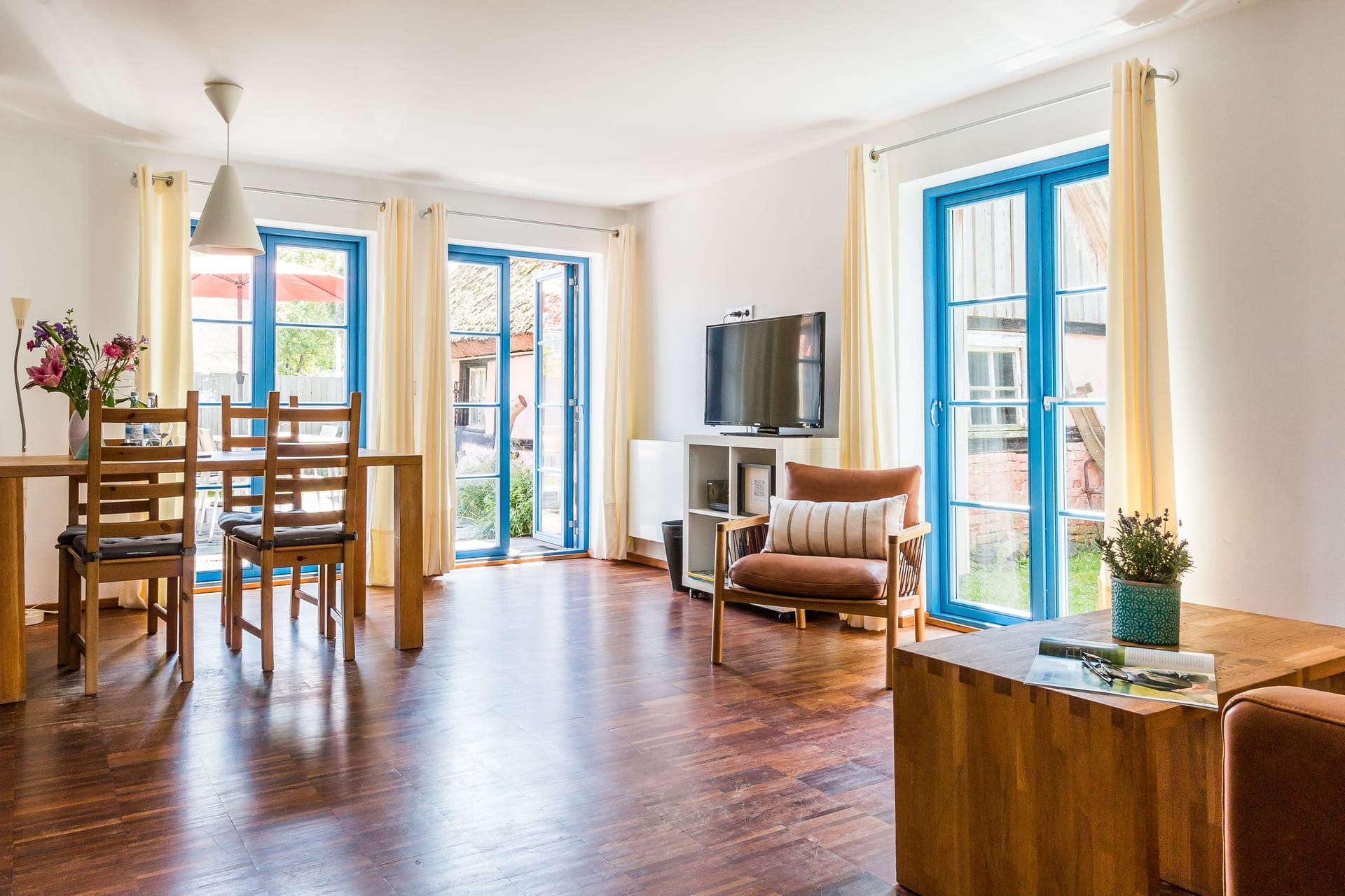 Gemütliches Wohnzimmer mit Esstisch und Fernseher