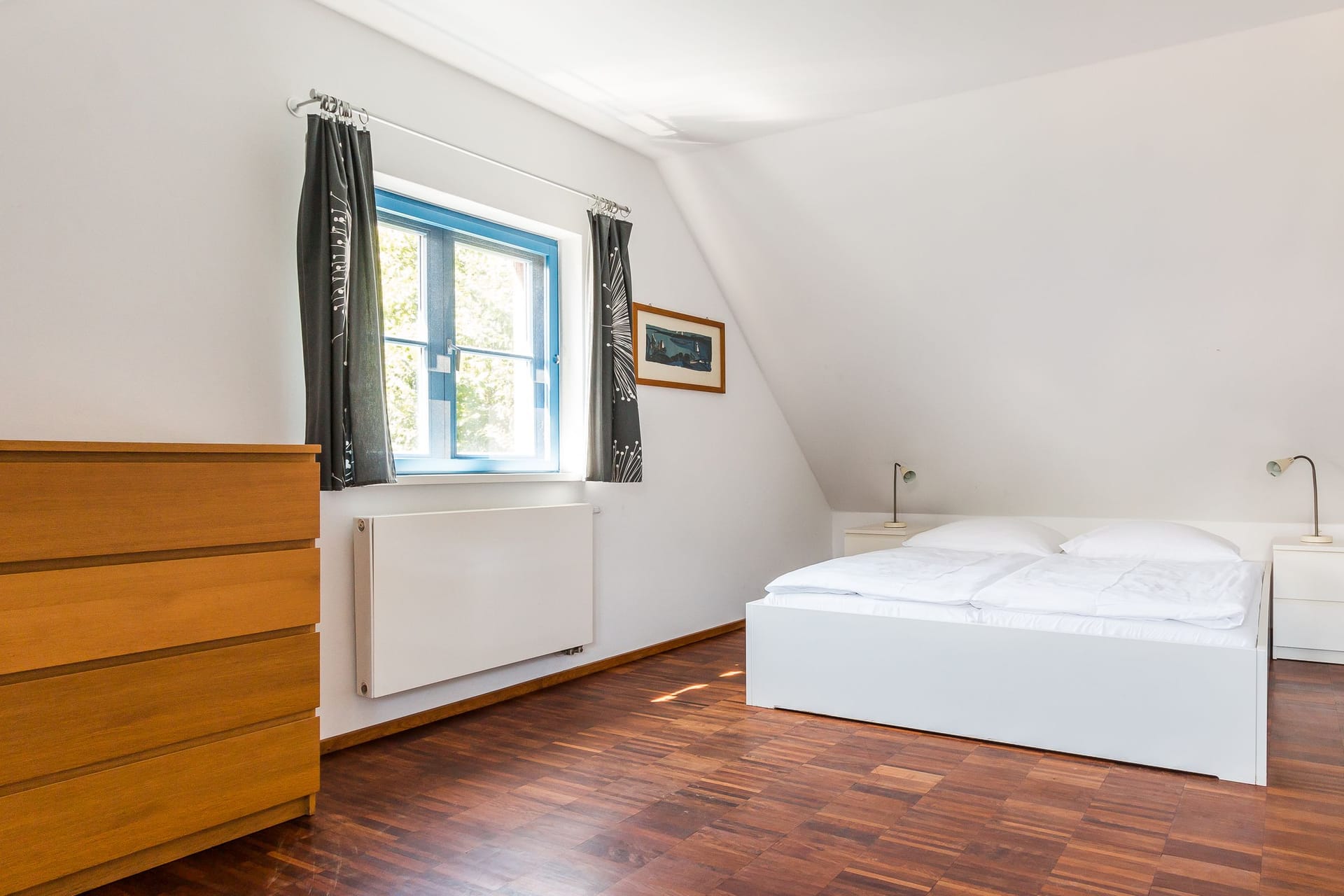 Helles Schlafzimmer mit Doppelbett und Holzschrank