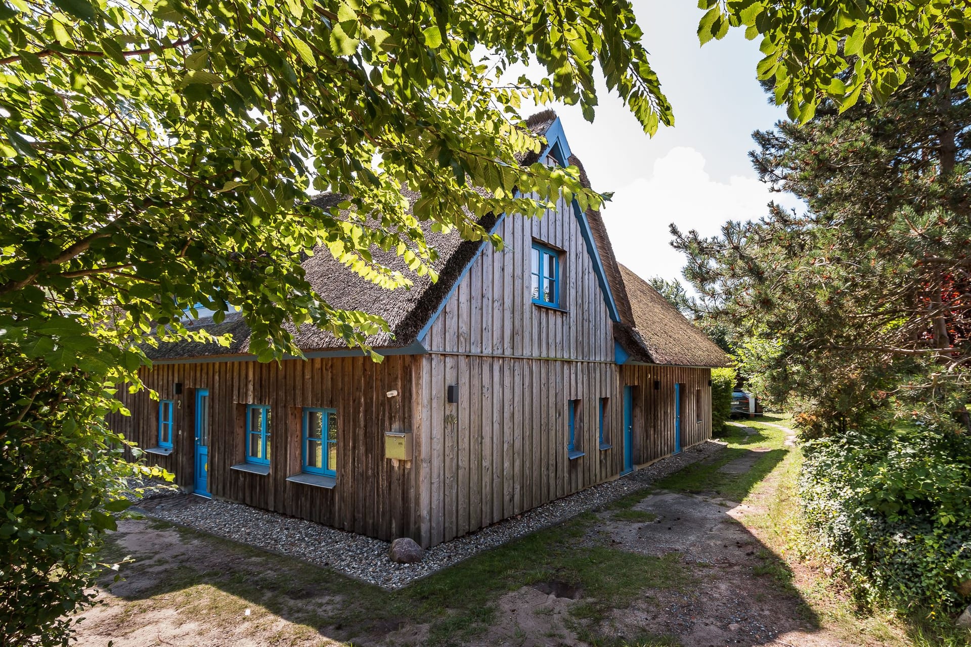 Außenansicht eines Holzhauses mit blauen Fenstern