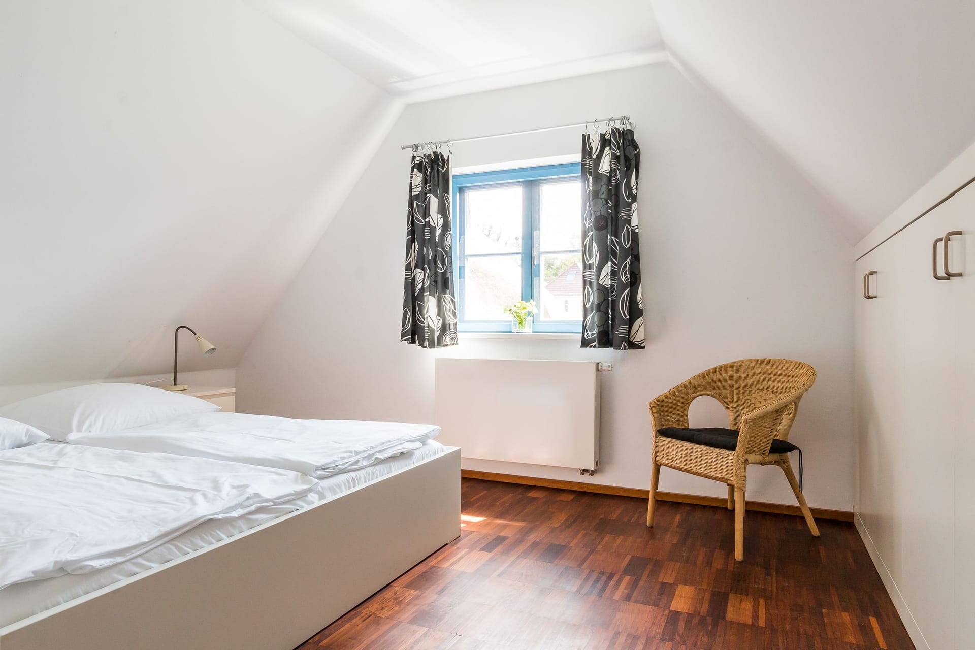 Schlafzimmer mit Fenster und Stuhl
