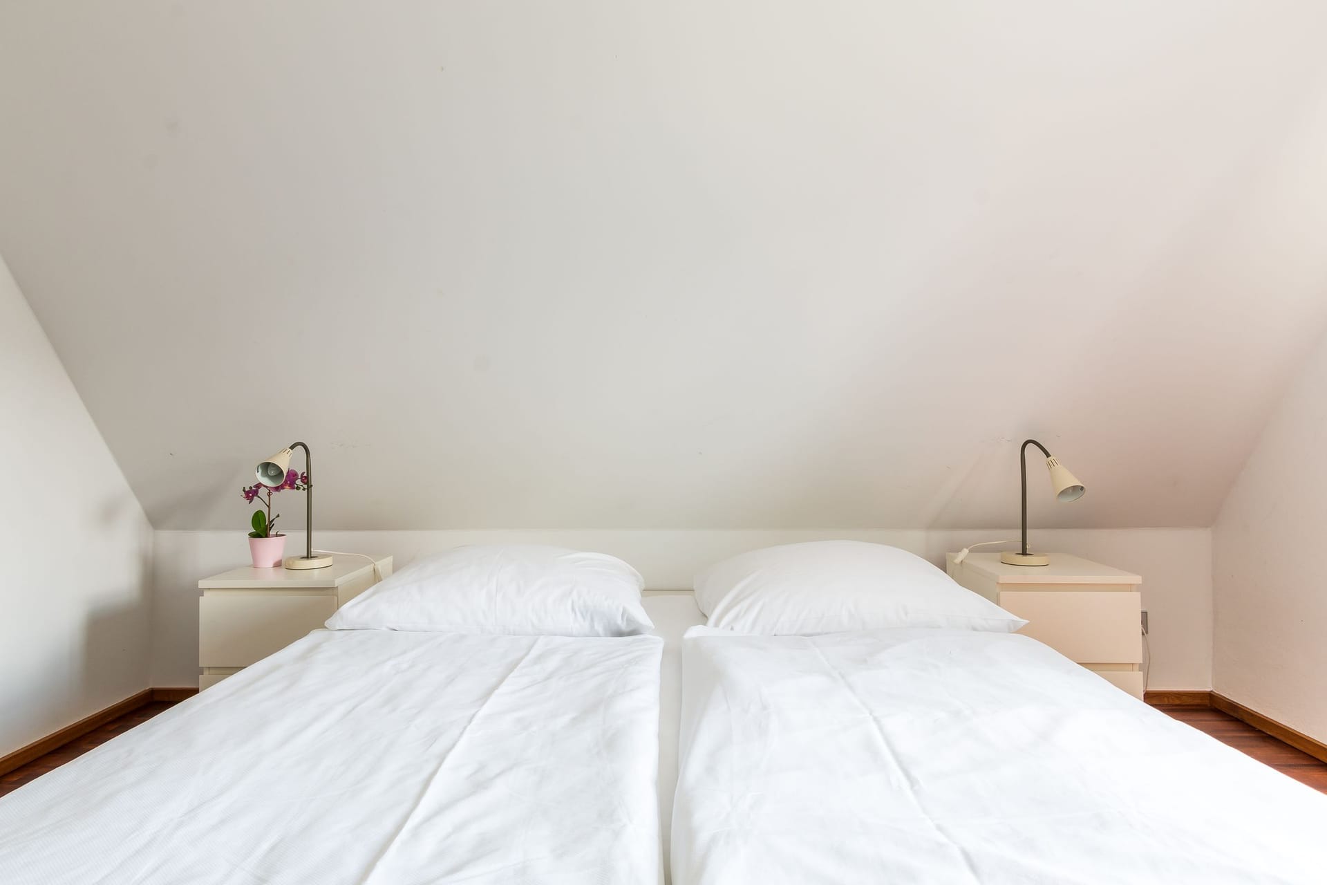 Schlafzimmer mit zwei Betten und Nachttischlampen