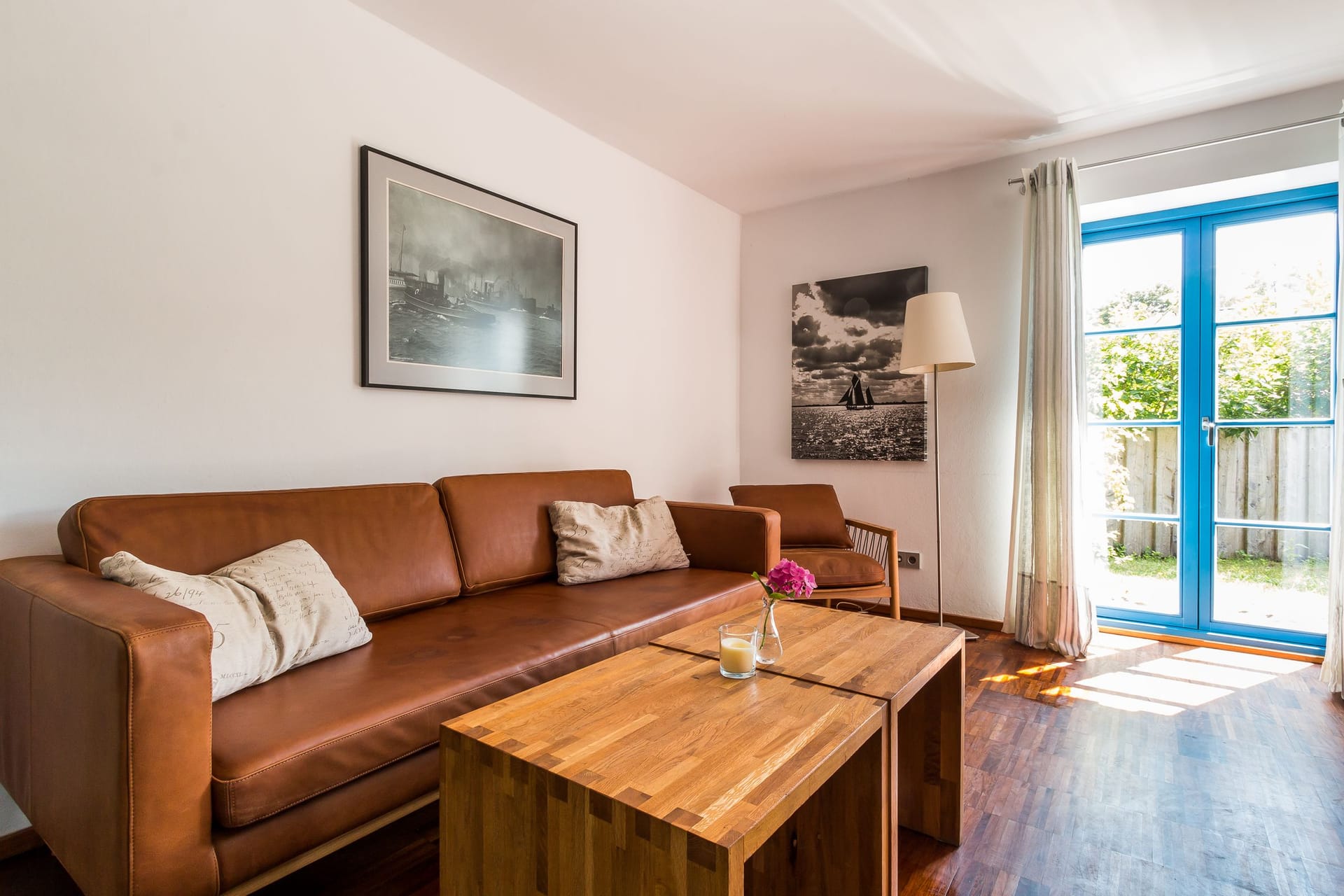 Gemütliches Wohnzimmer mit Ledersofa und Gartenausgang