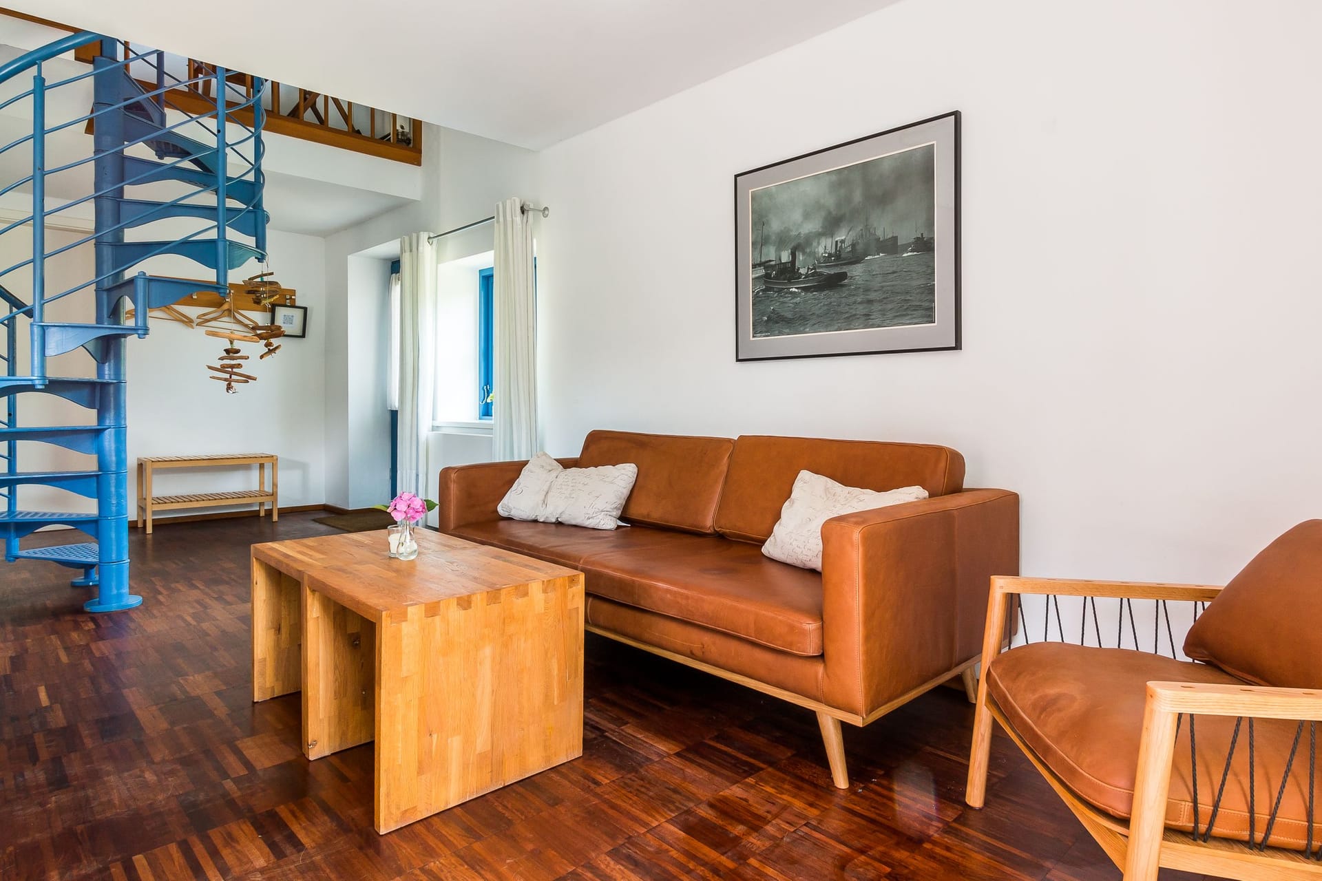 Gemütliches Wohnzimmer mit Sofa und Wendeltreppe