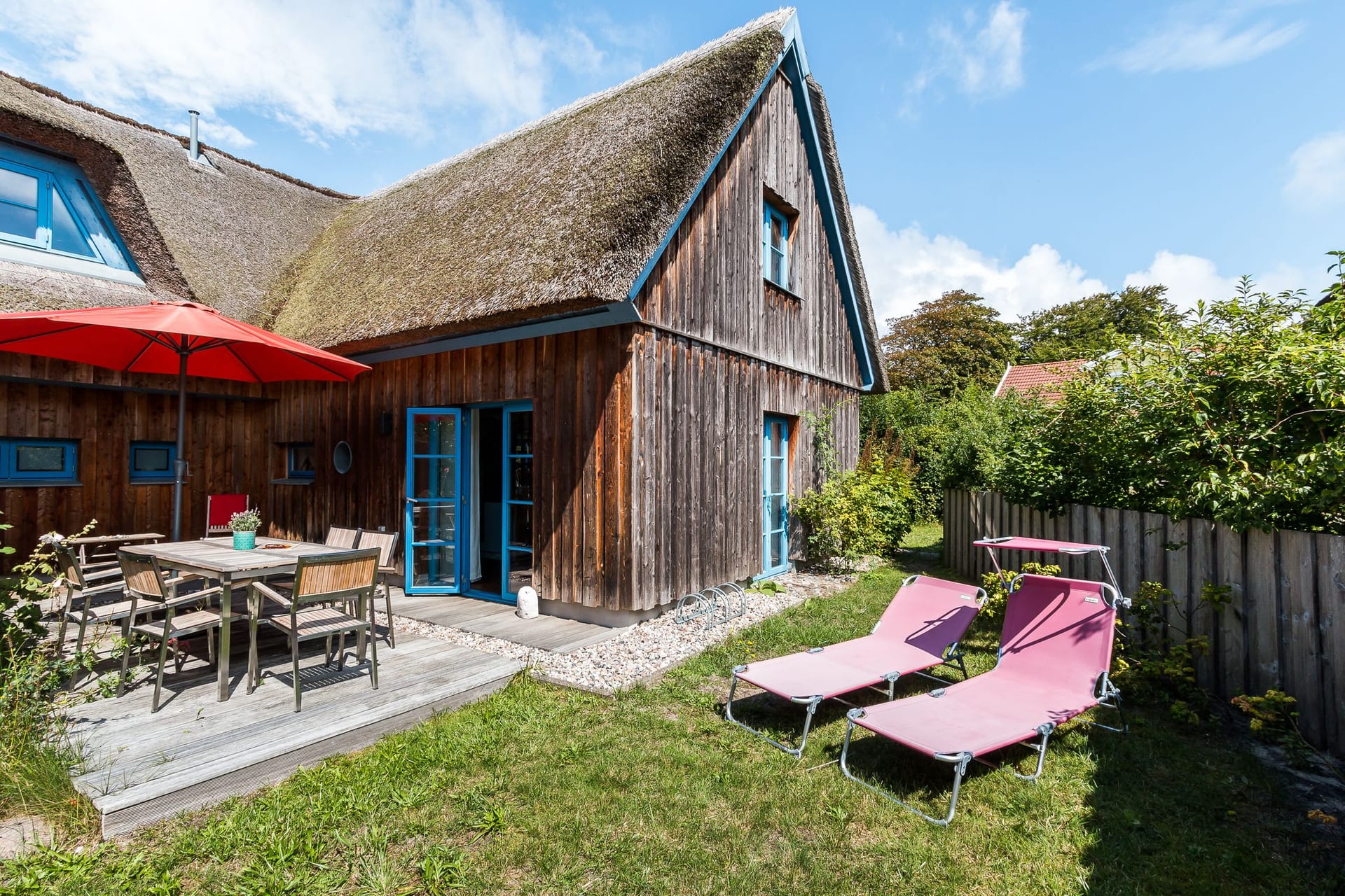 Einladendes Holzhaus mit Terrasse und Sonnenschirm