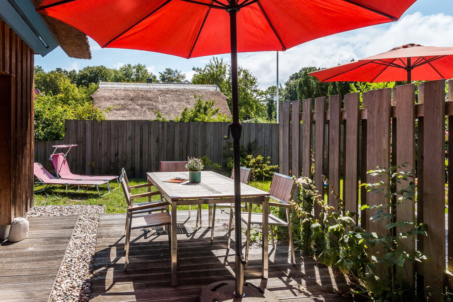 Gemütliche Terrasse mit roten Sonnenschirmen