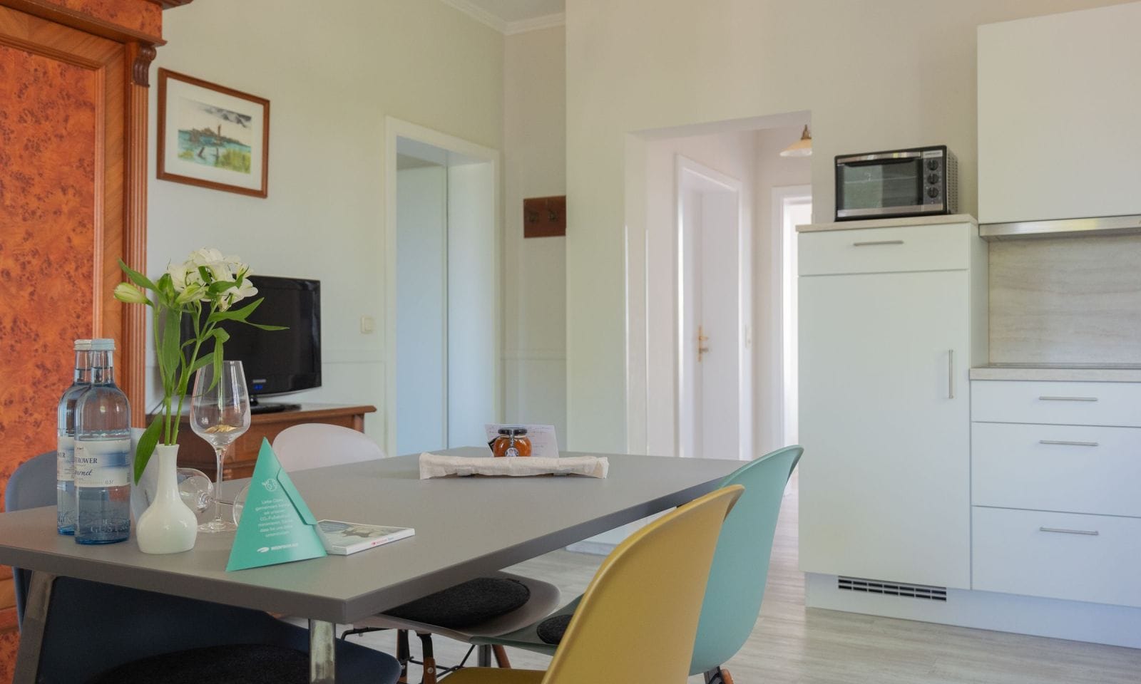 Moderne Küche mit Esstisch und bunten Stühlen