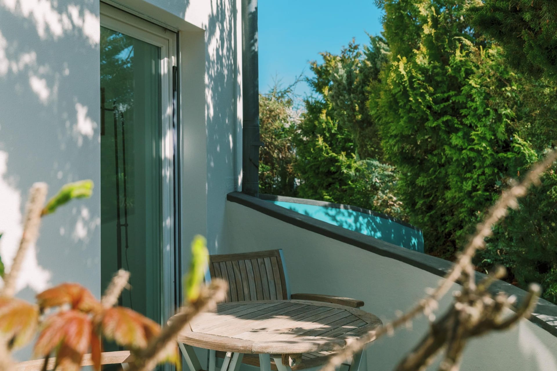 Balkon mit Holztisch und Blick ins Grüne