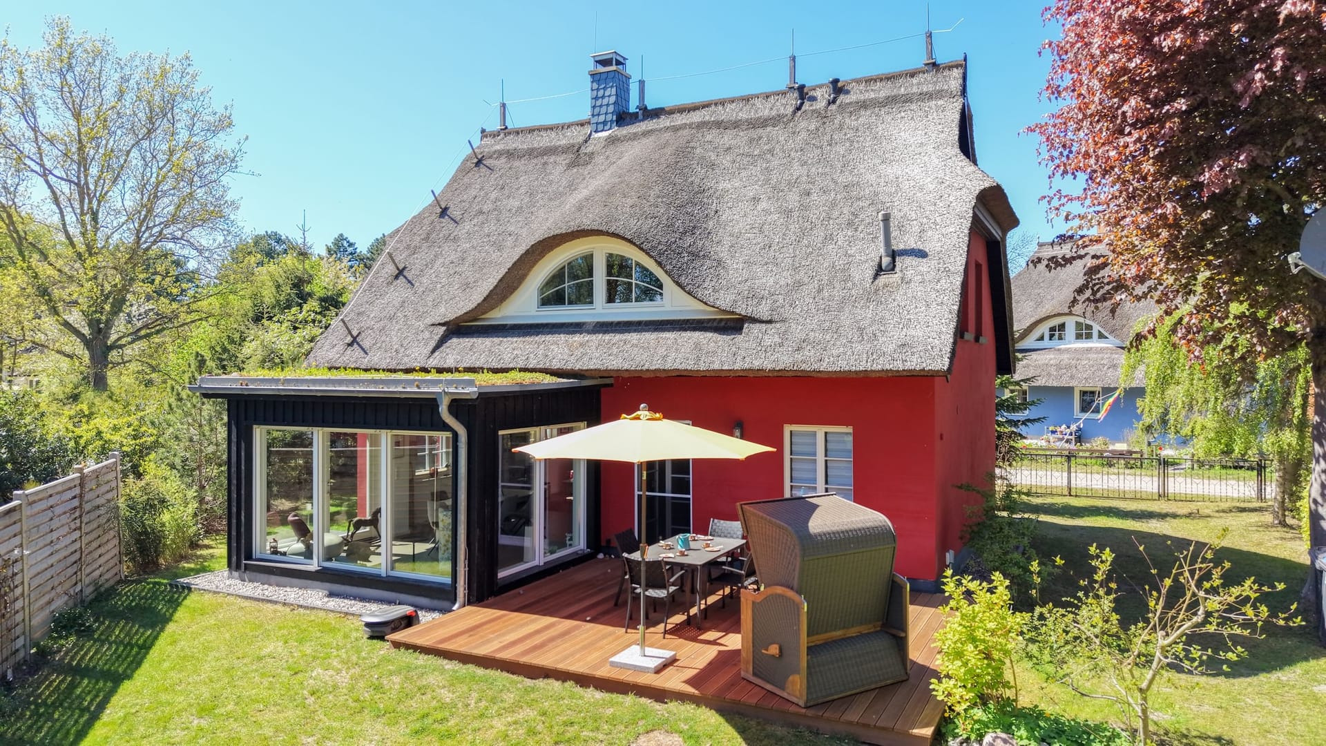 Außenansicht eines roten Hauses mit Reetdach