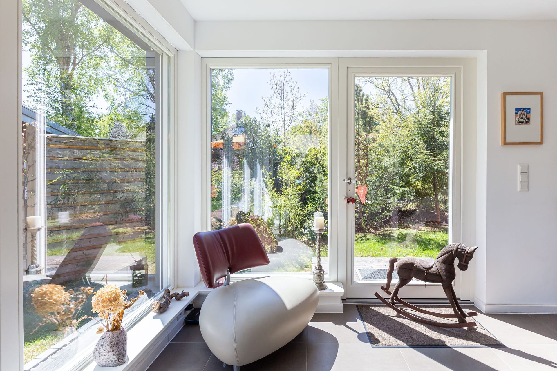 Wohnzimmer mit großen Fenstern und moderner Sitzgelegenheit
