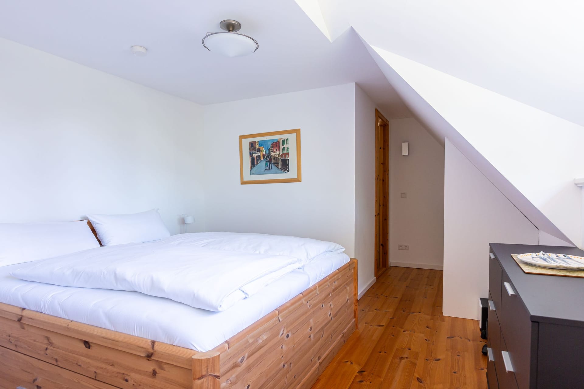 Schlafzimmer mit Doppelbett und stilvollem Holzboden