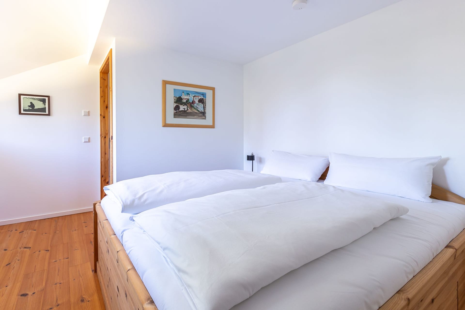Schlafzimmer mit Doppelbett und Kunstwerk