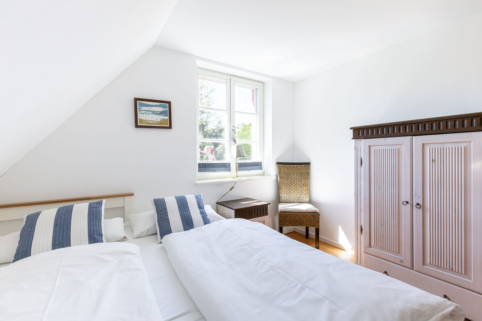 Helles Schlafzimmer mit zwei Betten und Fenster