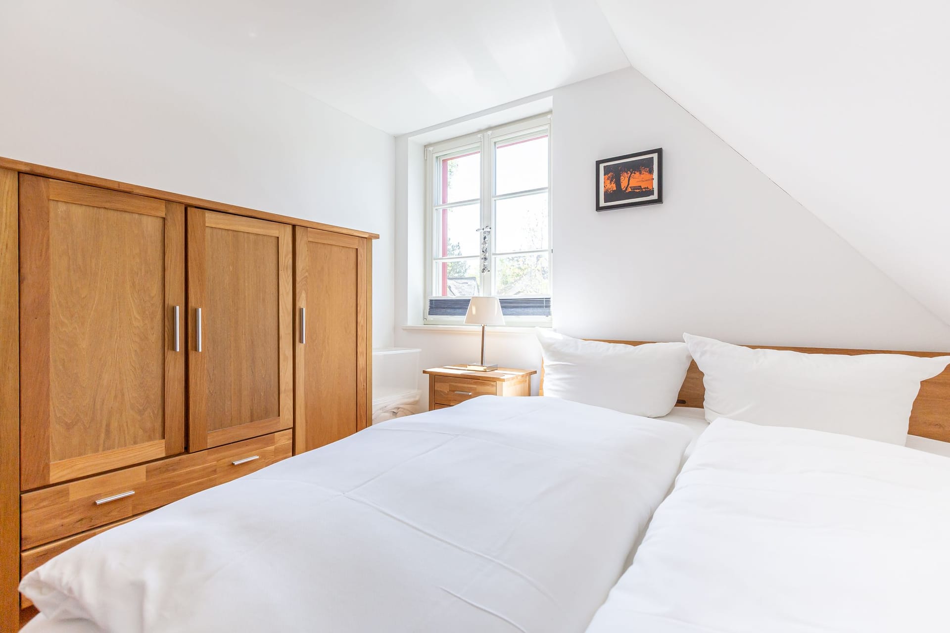 Schlafzimmer mit Doppelbett und Holzschrank