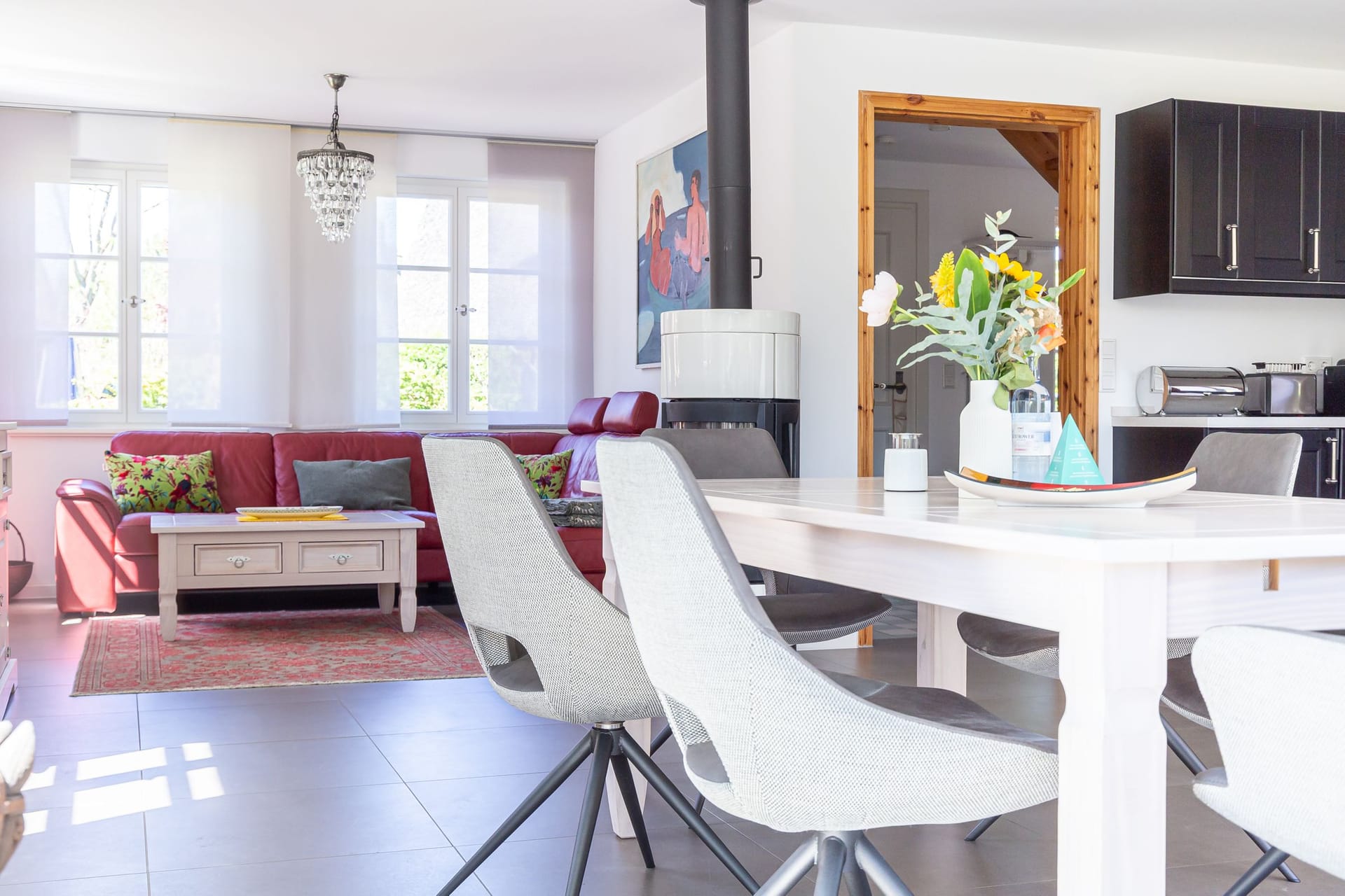 Wohnzimmer mit rotem Sofa und Esstisch
