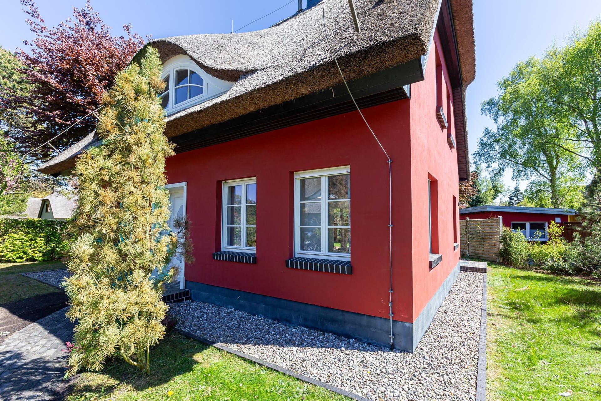 Außenansicht eines roten Hauses mit Reetdach
