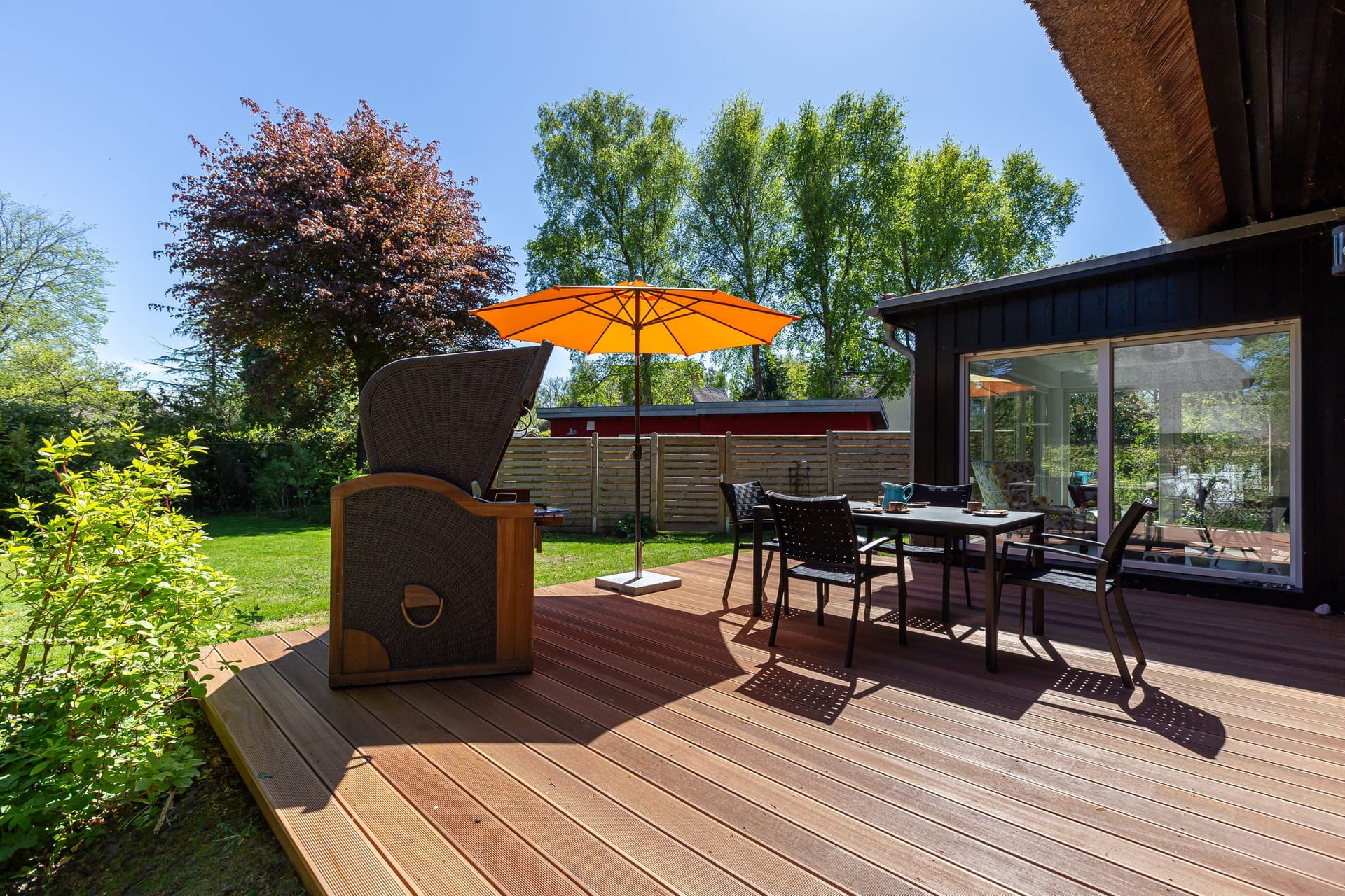 Terrasse mit Tisch, Stühlen und Sonnenschirm