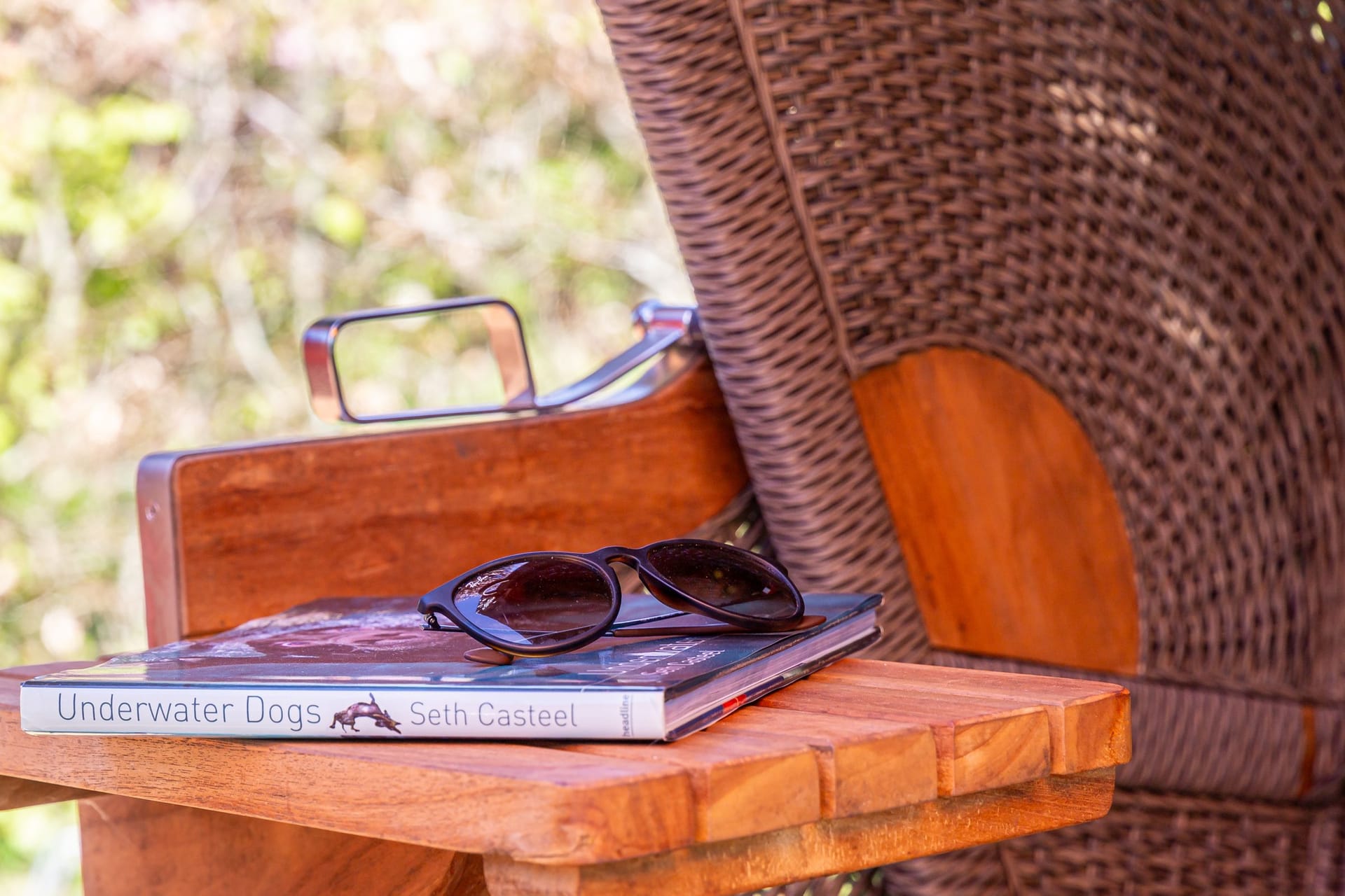 Terrasse mit Tisch, Buch und Sonnenbrille