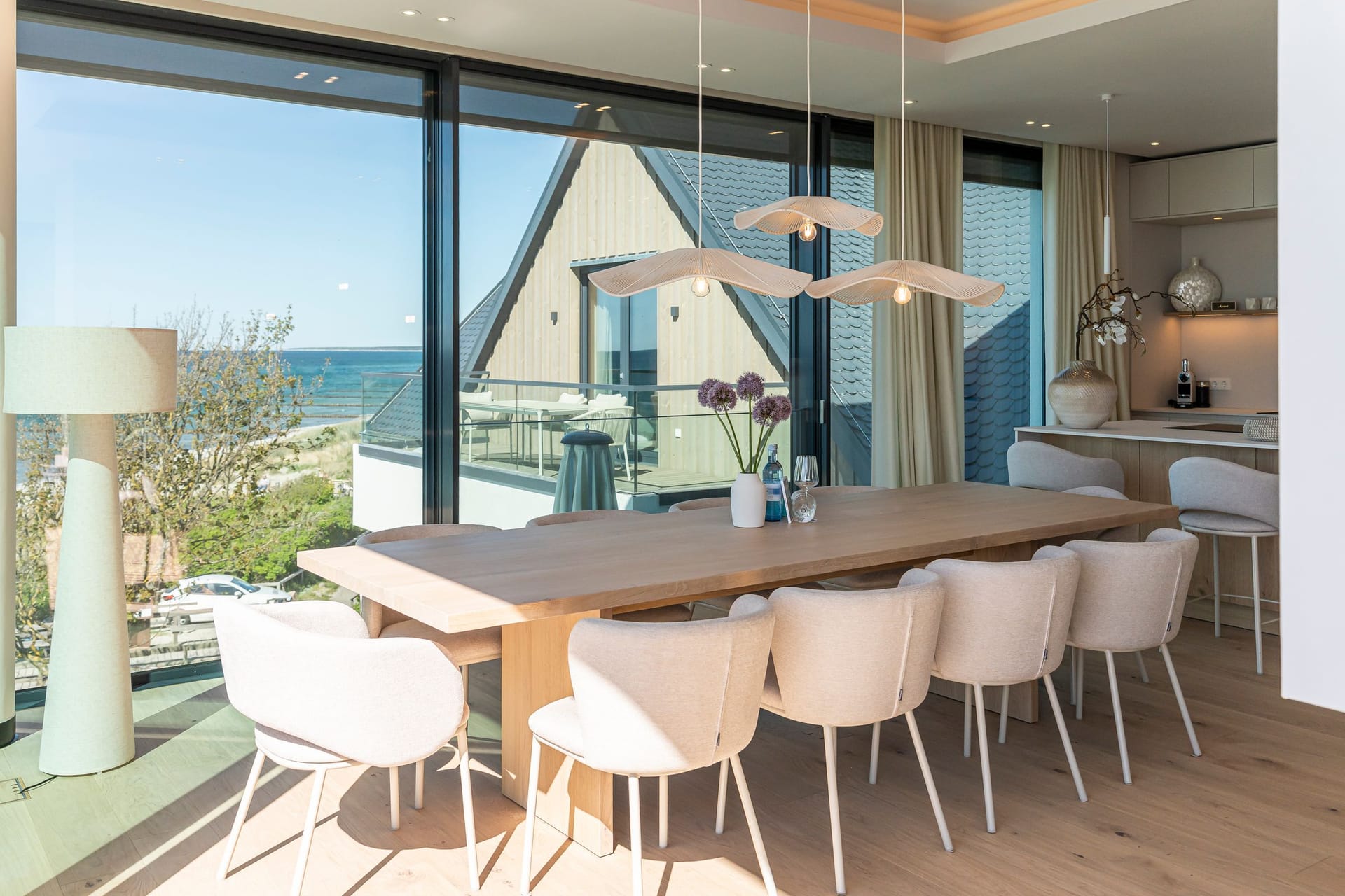 Moderne Küche mit Esstisch und Meerblick