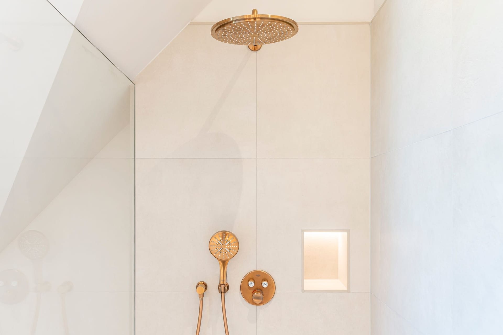 Moderne Dusche mit goldenen Armaturen