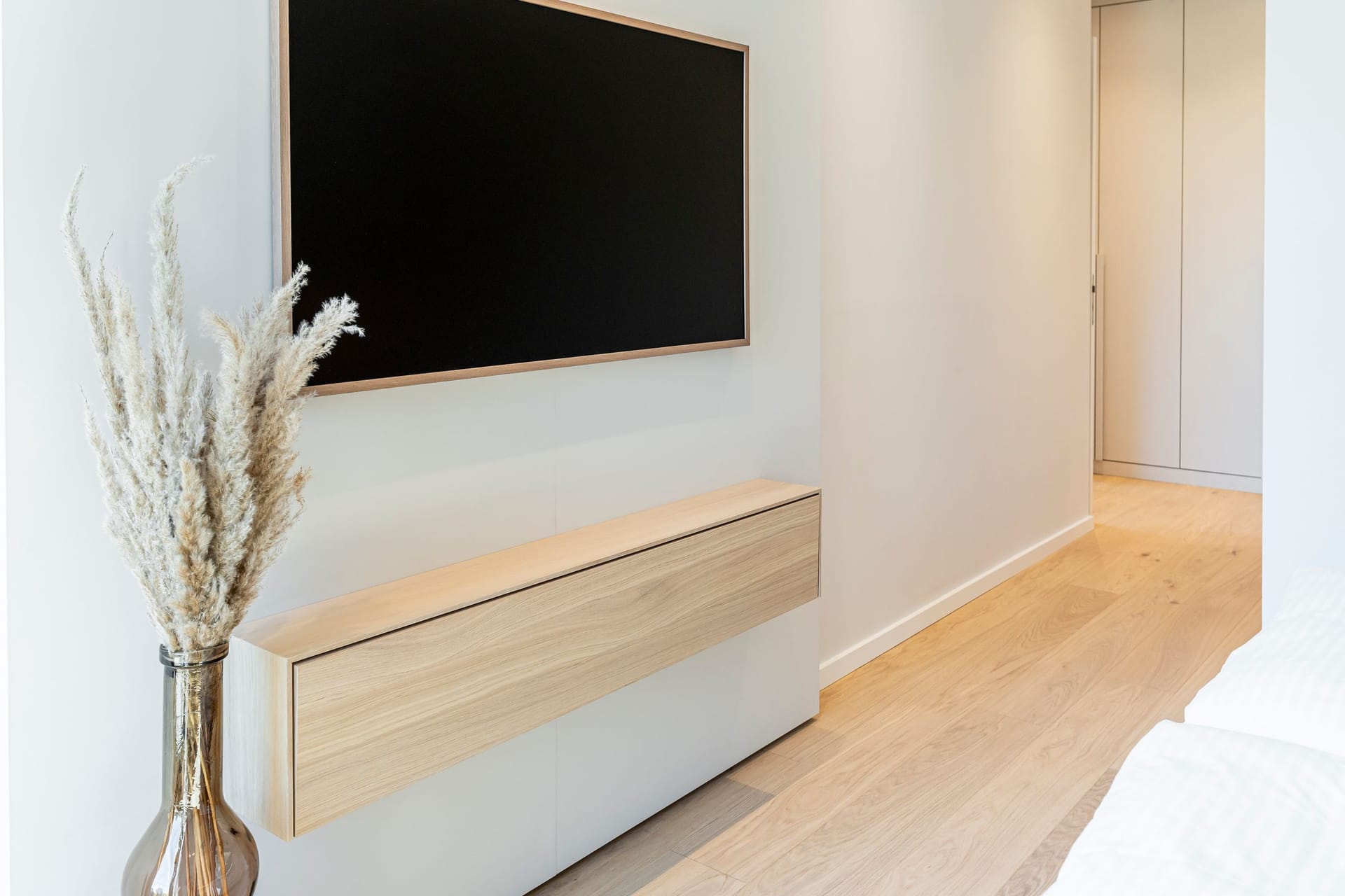 Schlafzimmer mit Fernseher und Holzkommode