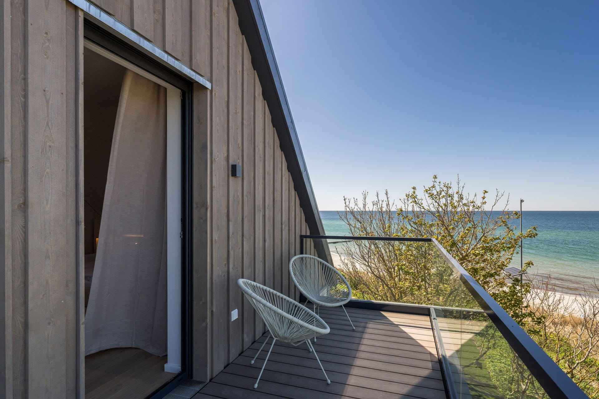 Balkon mit Meerblick und modernen Stühlen