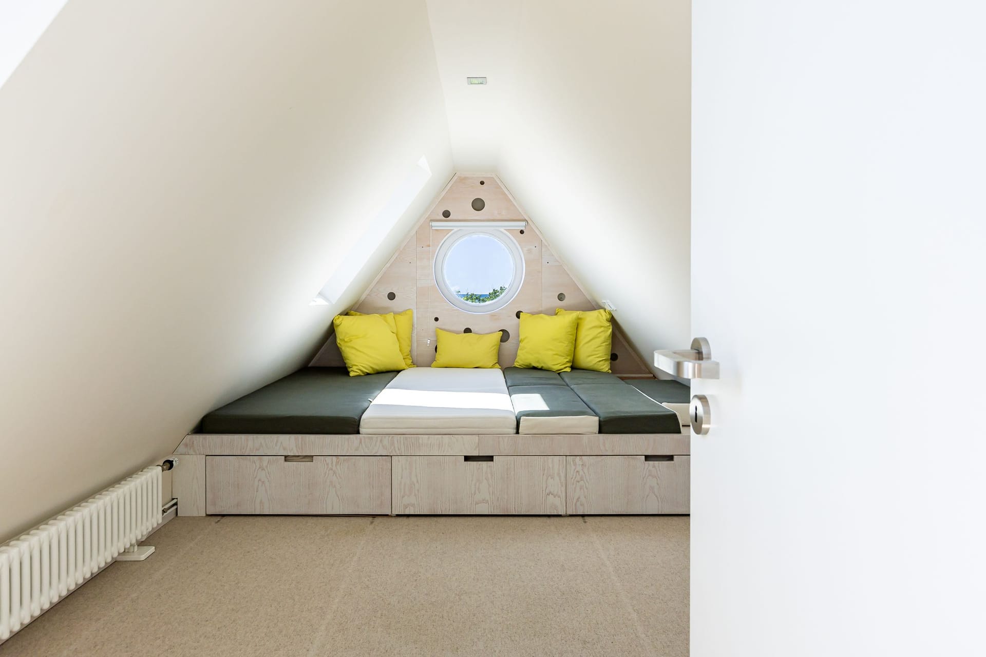 Schlafzimmer mit Bett und rundem Fenster