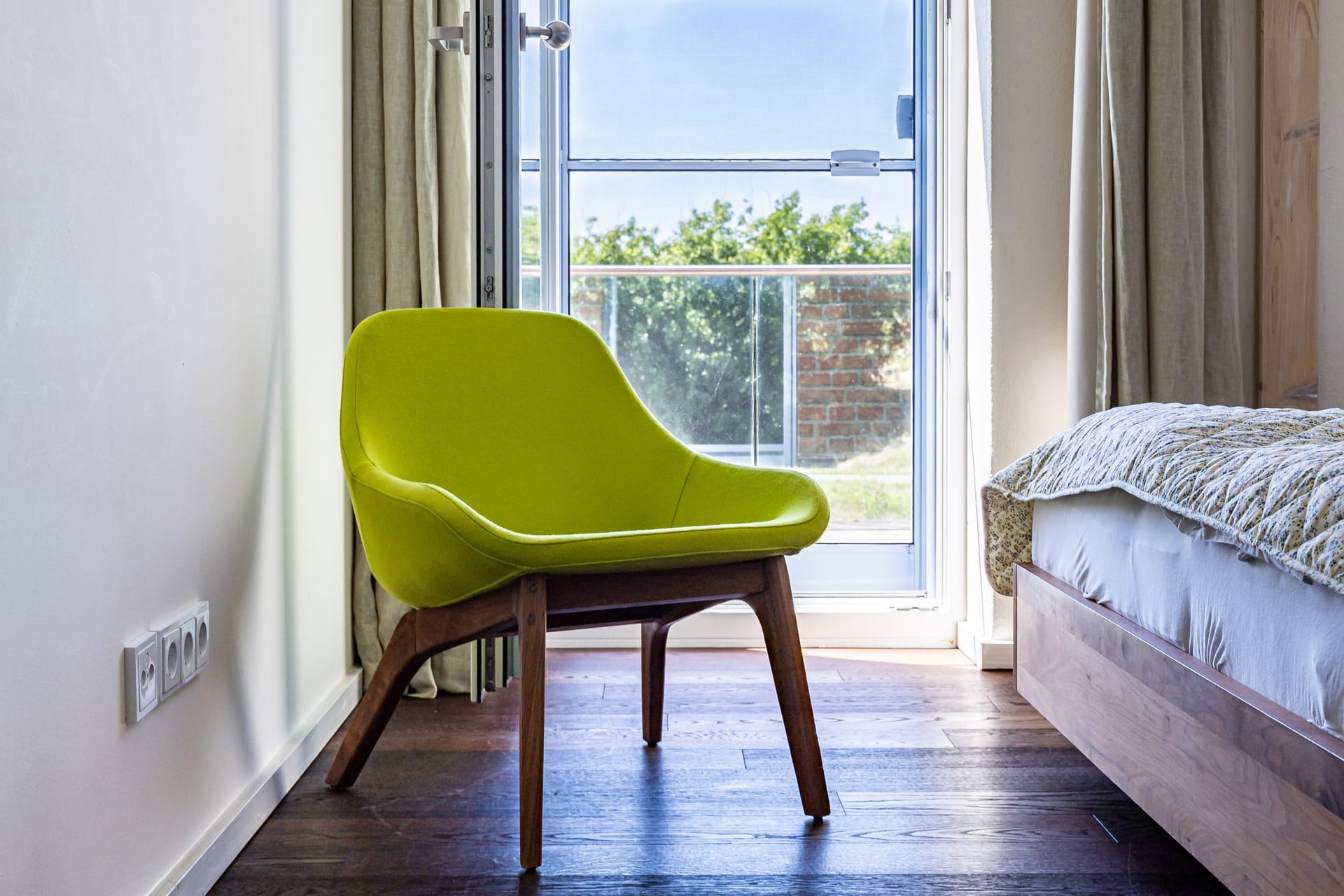 Schlafzimmer mit modernem Stuhl und Balkonblick