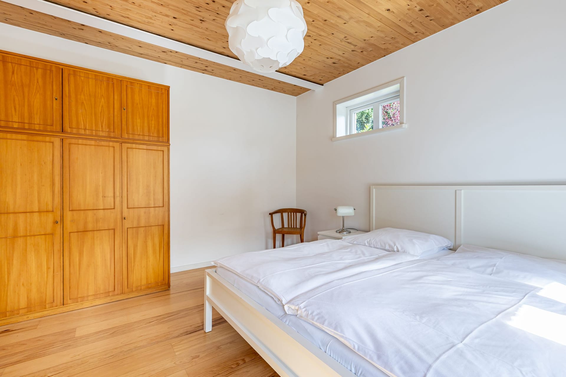 Schlafzimmer mit Doppelbett und Holzschrank