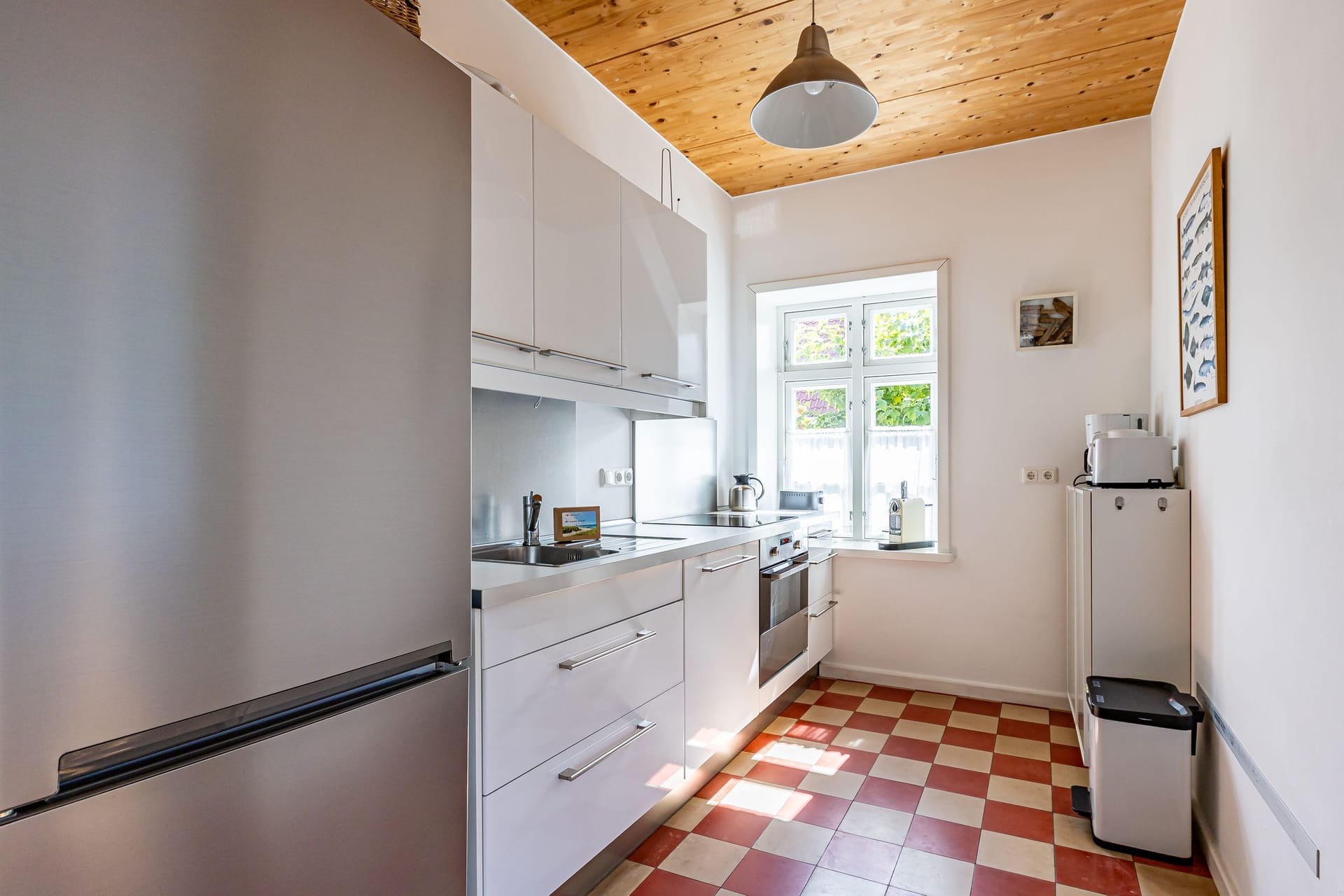 Moderne Küche mit weißen Schränken und Fenstern