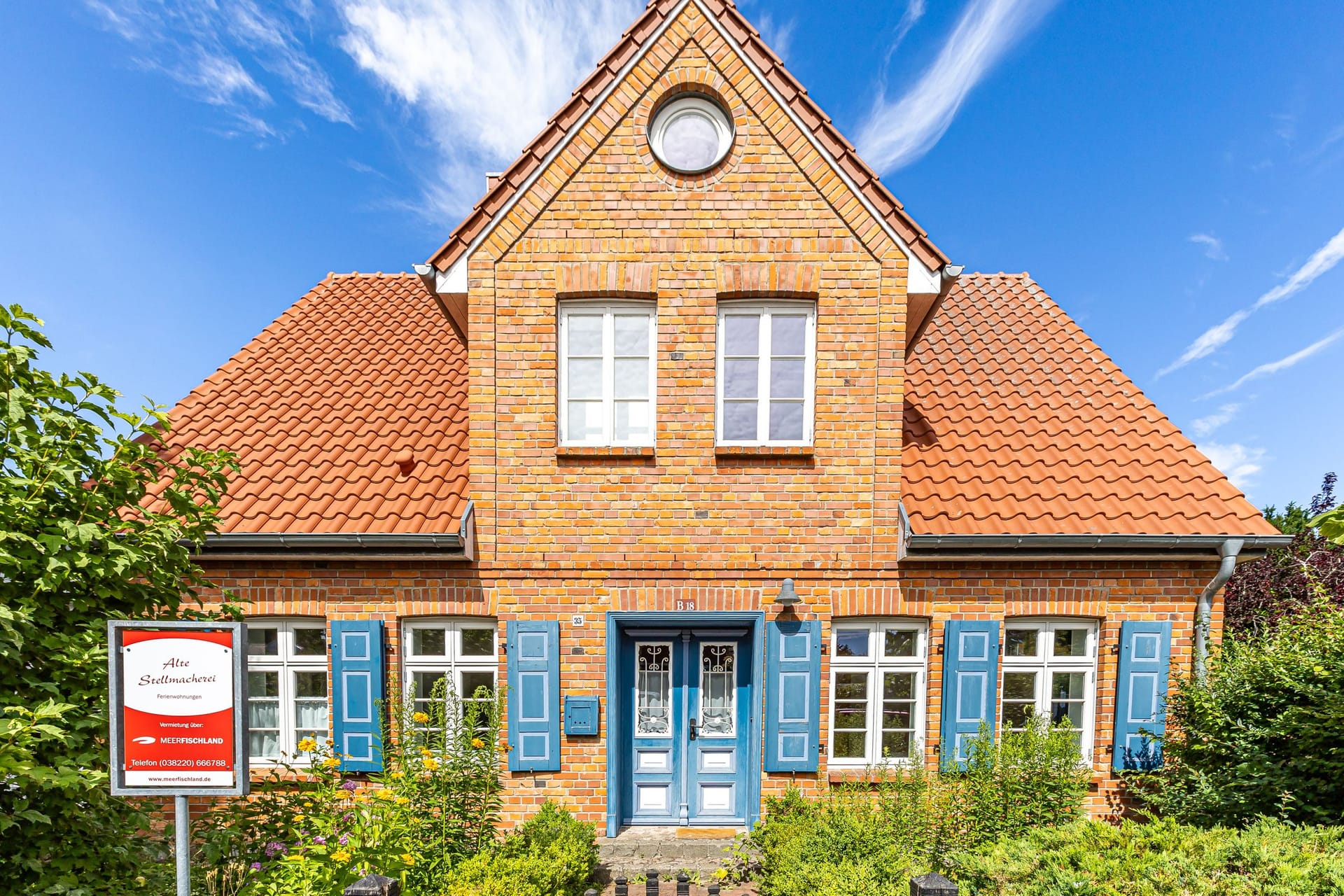Historisches Kapitänshaus mit roten Ziegeln und blauen Fensterläden