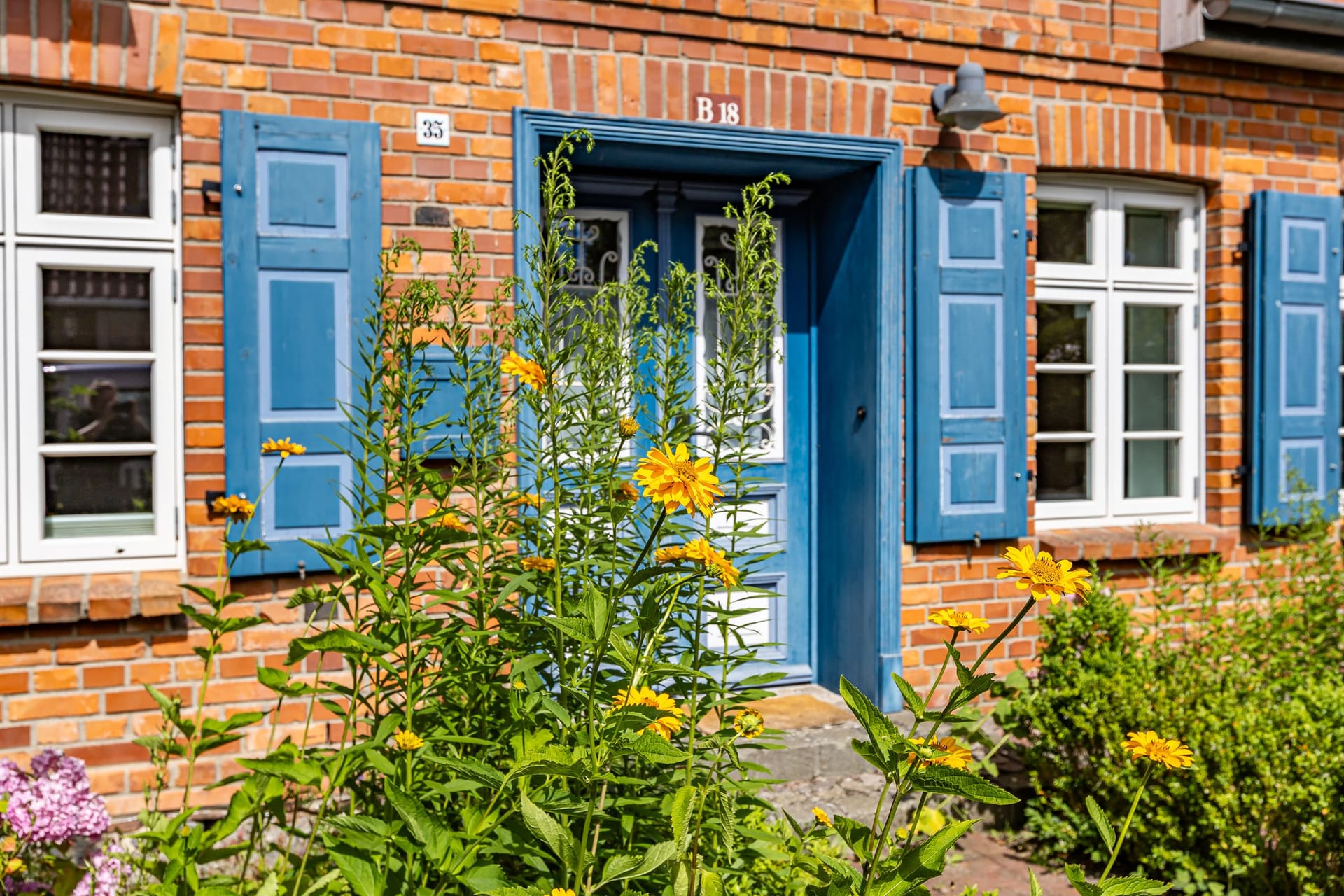 Eingang zu einem charmanten Haus mit blauen Fensterläden