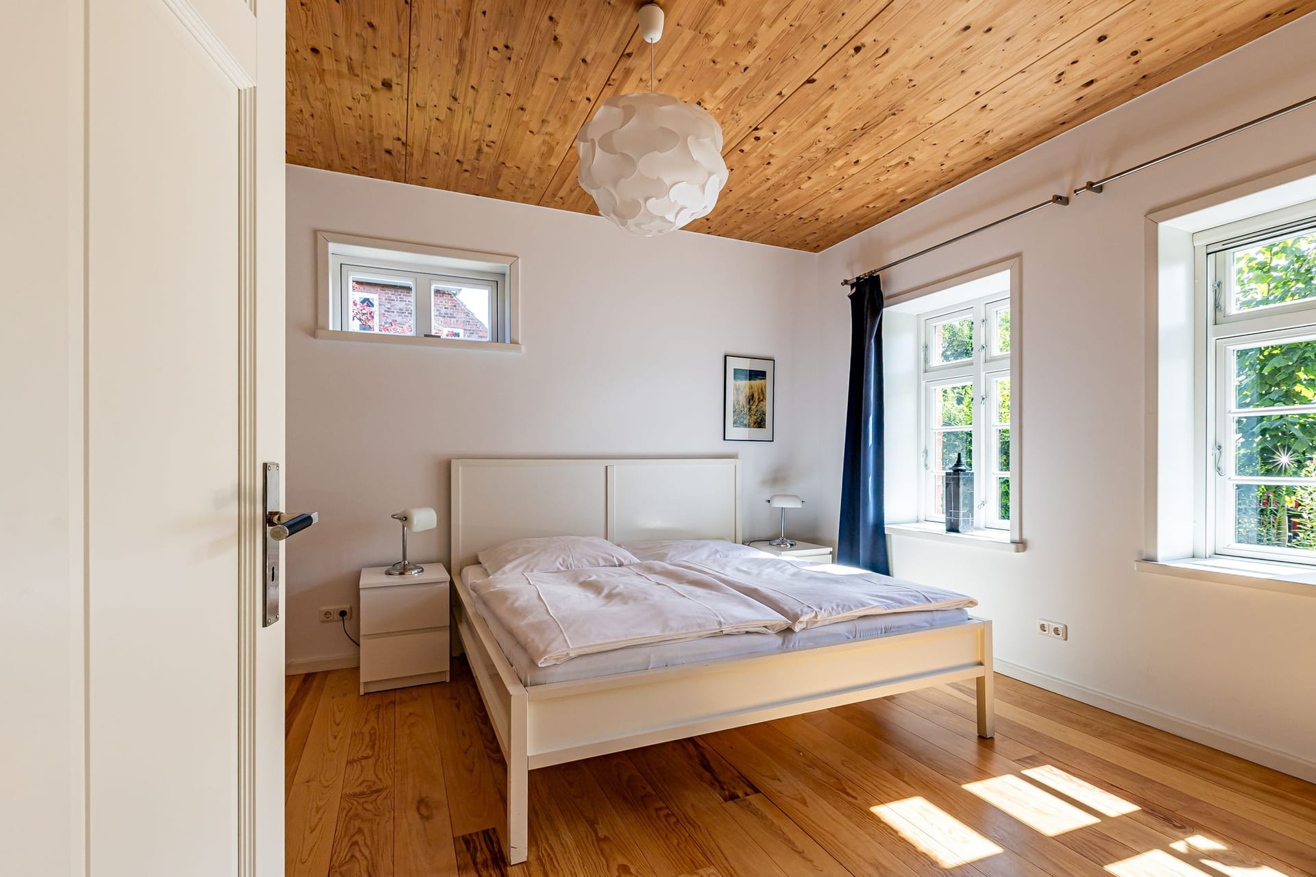 Schlafzimmer mit Doppelbett und Fenstern