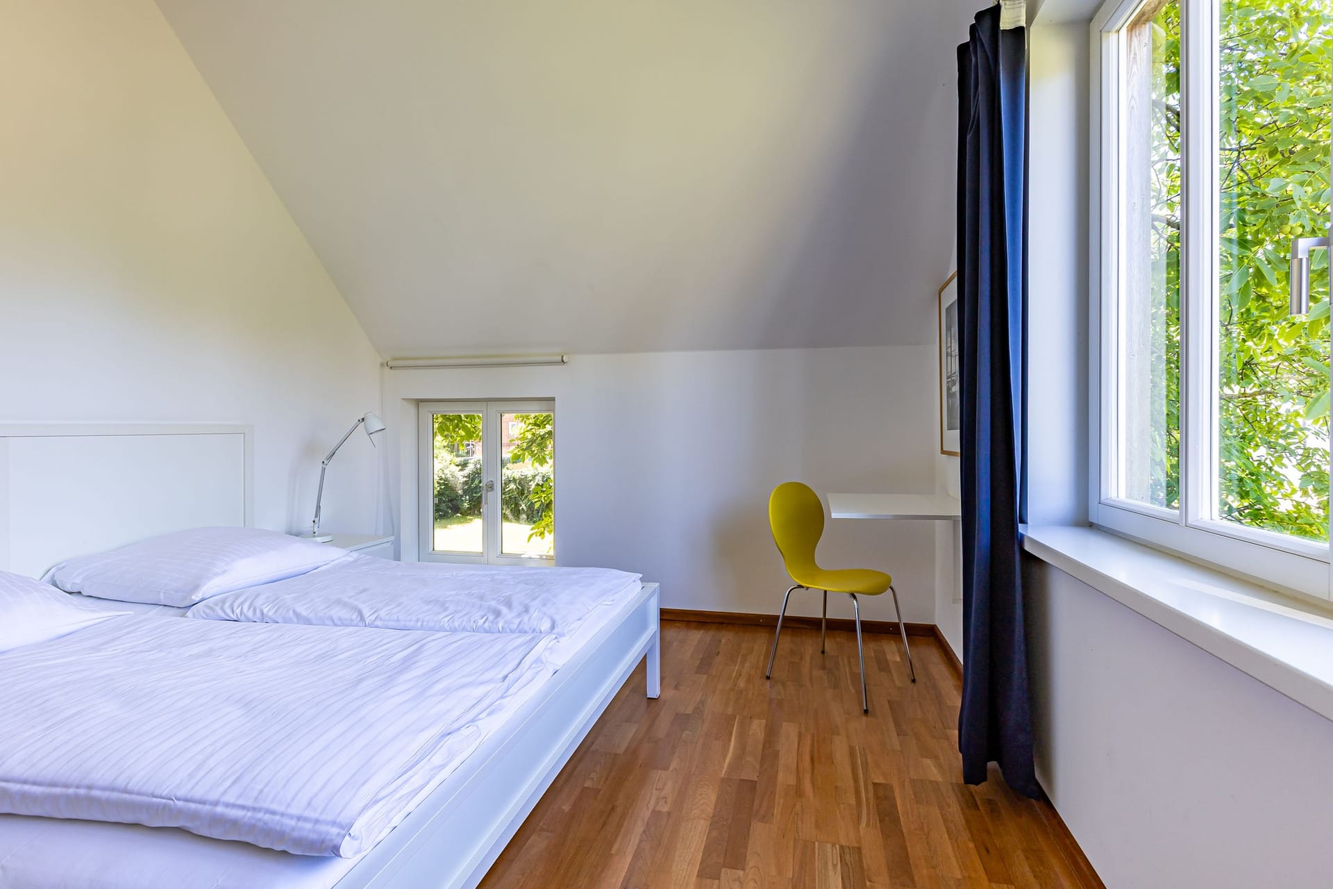 Schlafzimmer mit Doppelbett und Schreibtisch