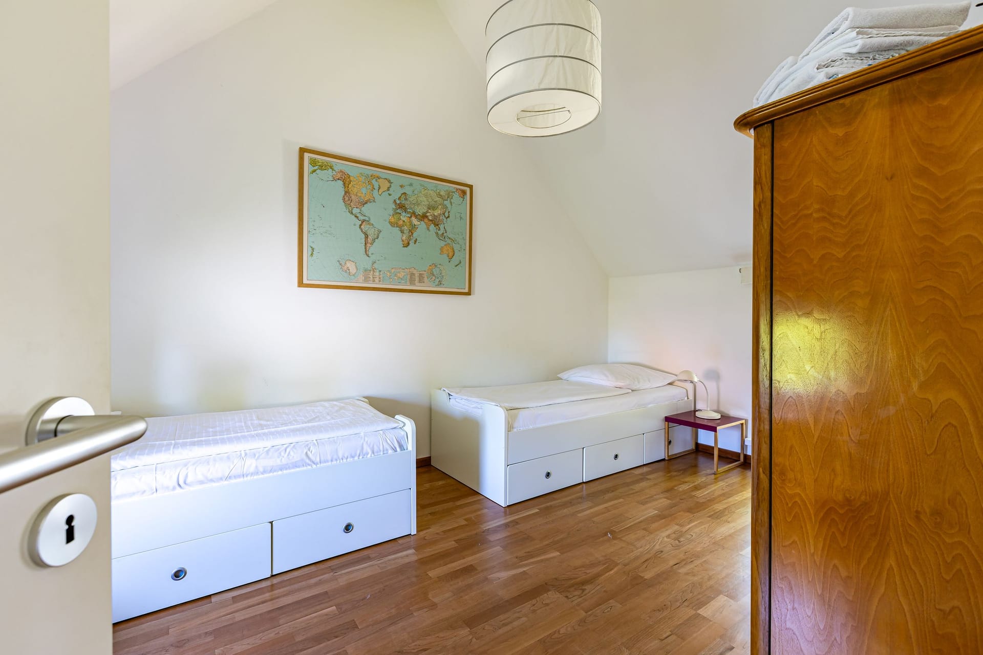 Schlafzimmer mit zwei Einzelbetten und Weltkarte